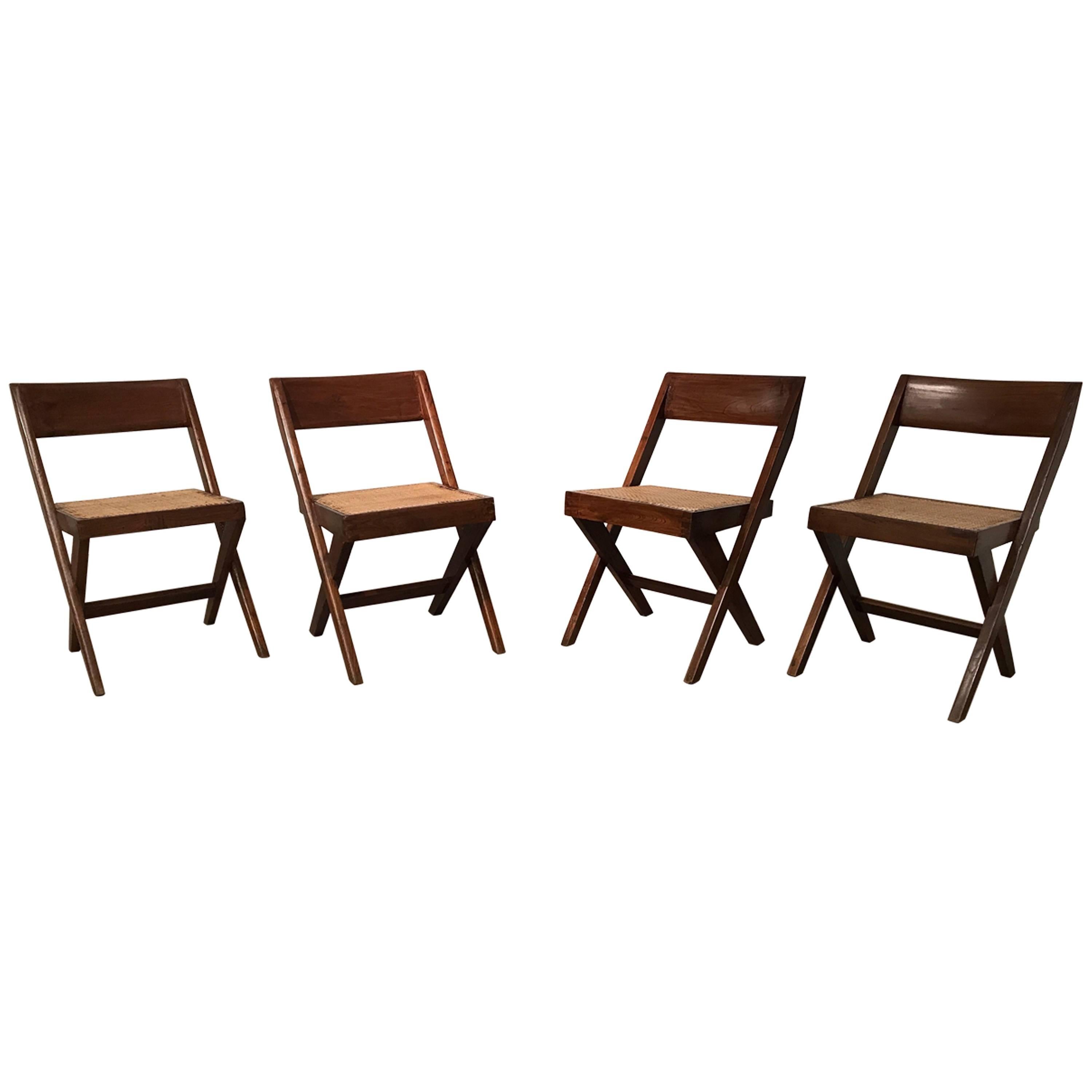 Set of six teak library chairs designed by Pierre Jeanneret for the Central Library of Punjab University, Chandigarh. Solid lacquered teak frame with woven cane seat. 
Provenance: Central Library of Punjab University, Chandigarh, India / Private