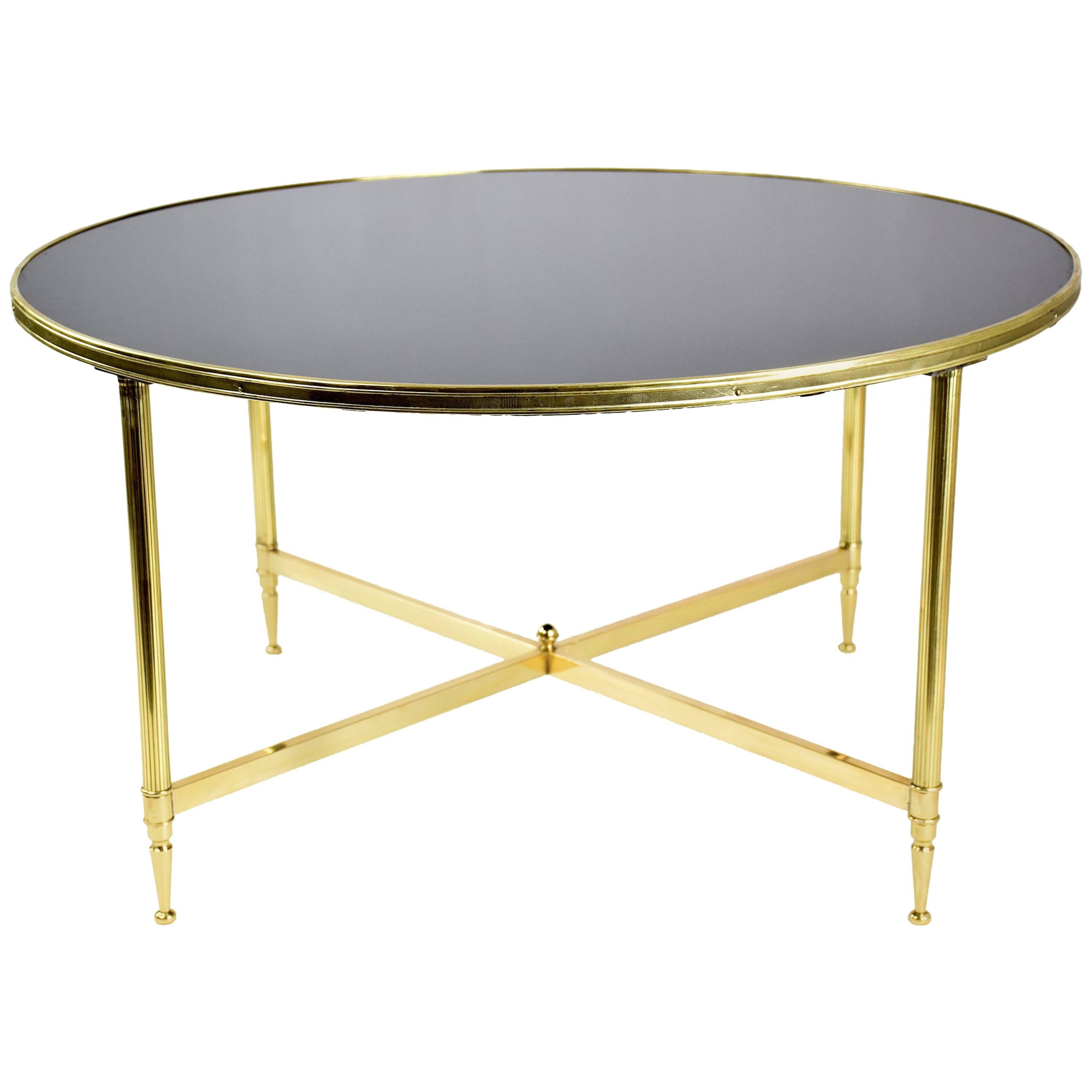 20th century vintage Hollywood Regency style French midcentury circular coffee or side table attributed to Maison Jansen composed of an intricate bronze cross-shaped structure and its original black tinted glass tabletop.
 
France, circa 1970s.