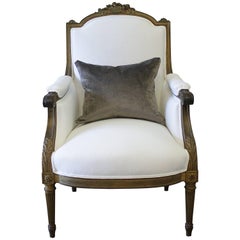 Antica sedia bergere in legno dorato in stile Luigi XVI con lino bianco