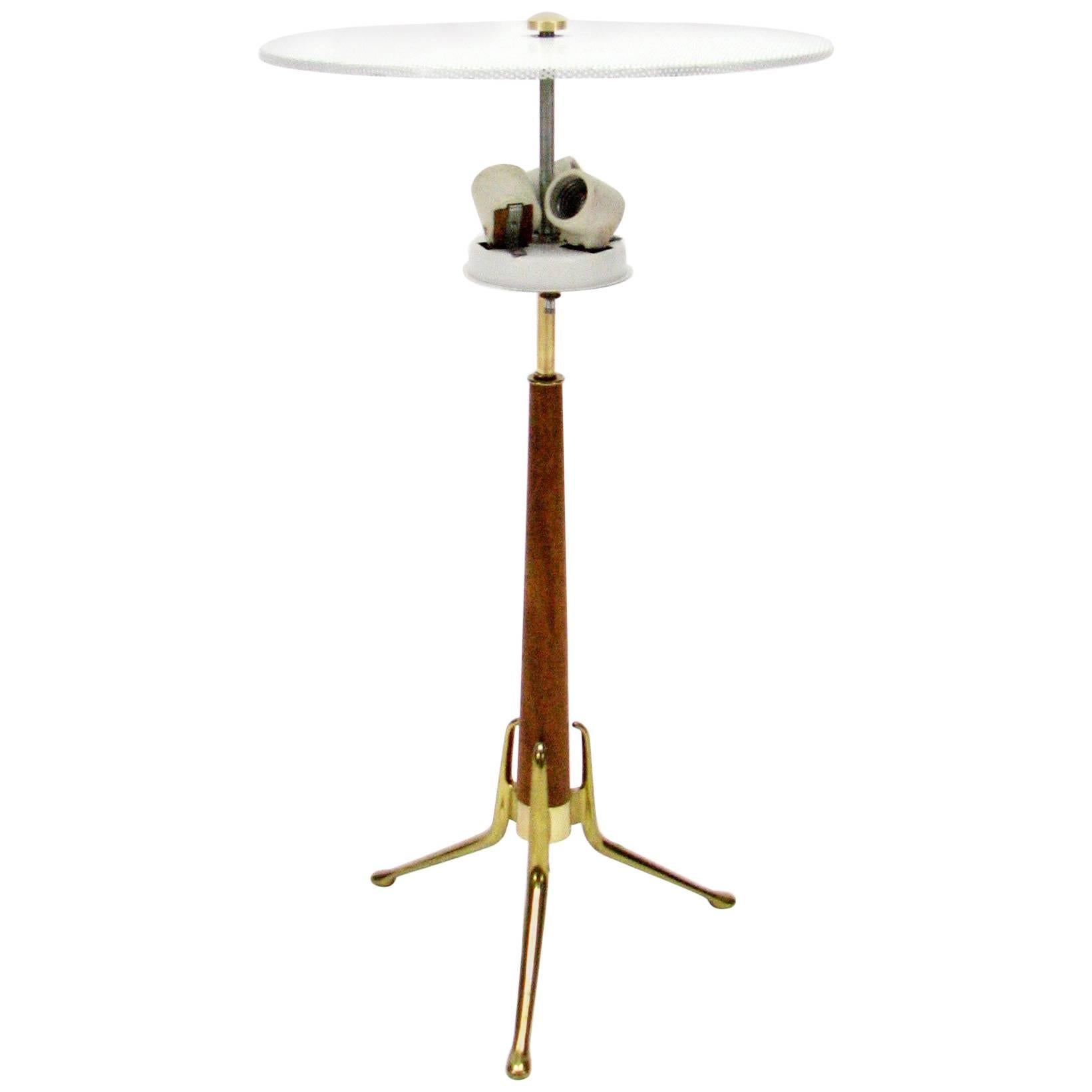 This walnut and brass lamp standing on a trio of brass legs was created by Gerald Thurston for Lightoilier, circa 1960s.

Original lampshade diffuser. Three-light bulb sockets.
