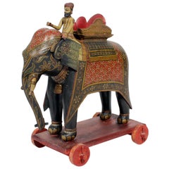 Grand éléphant et cavalier peints sur socle à roulettes