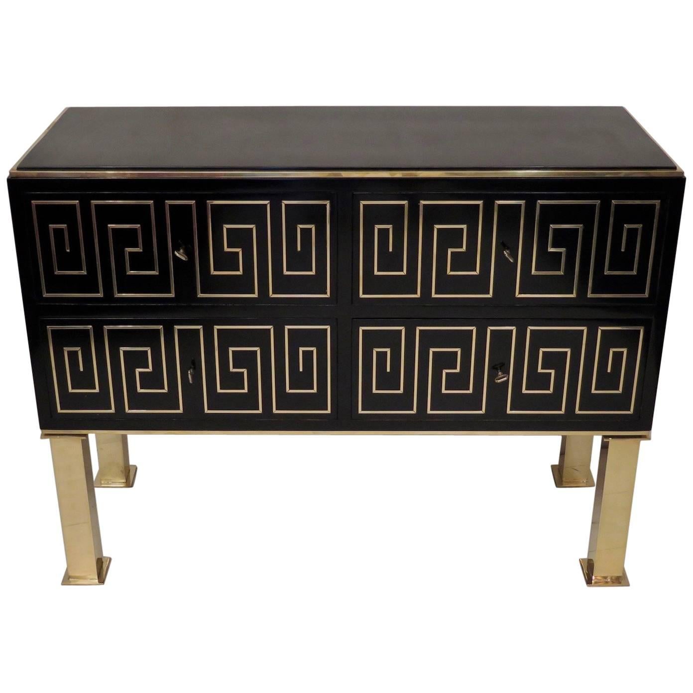 1950 Italian midcentury chest of drawers. The dresser is of parallepiped shape, all polished in black lacquer, with brass inlays on the front of the drawers. Precisely, brass rods were inserted to form a Greek. There are four drawers, and it can be