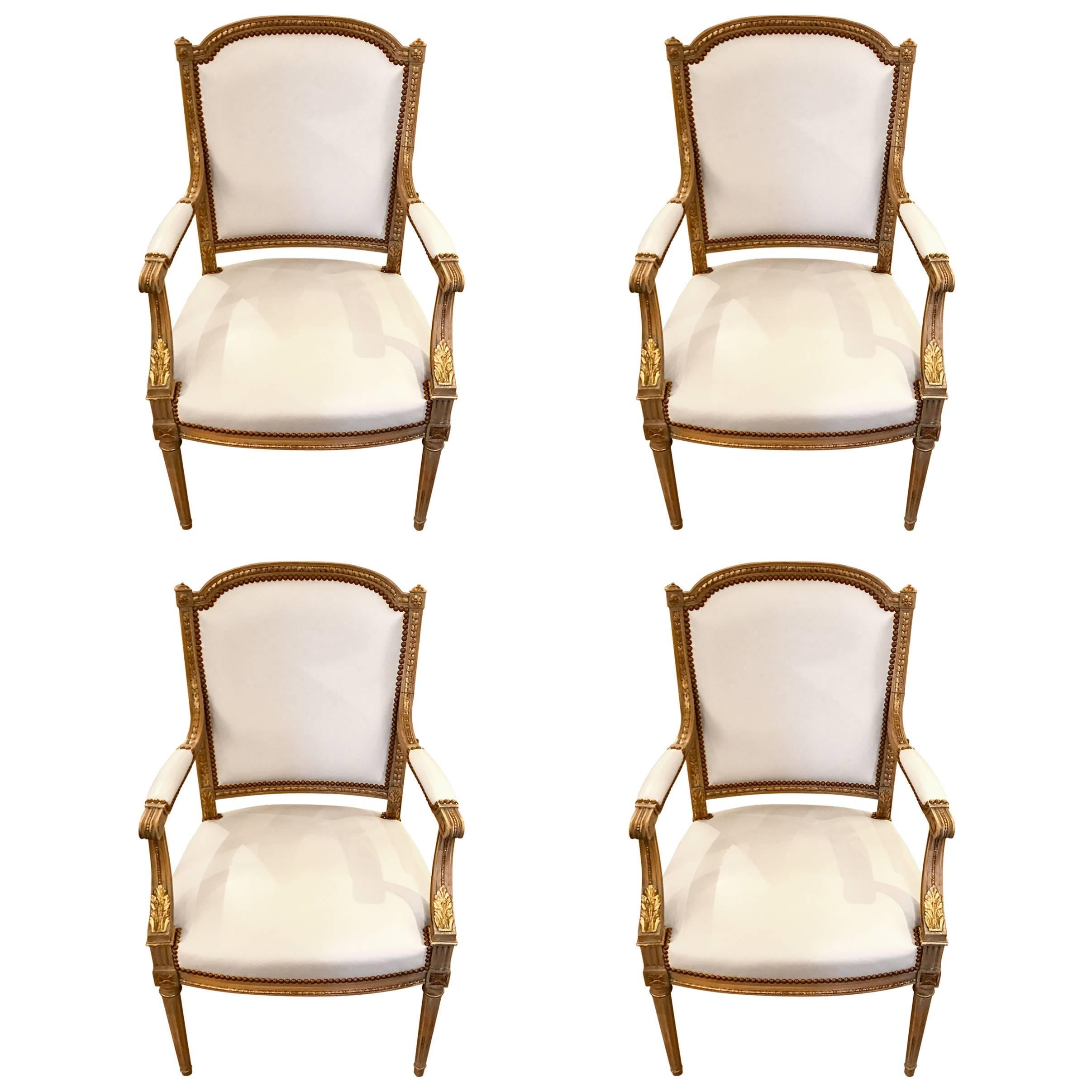 Four Maison Jansen Louis XVI Cream Leather Upholstered Parcel-Gilt Armchairs