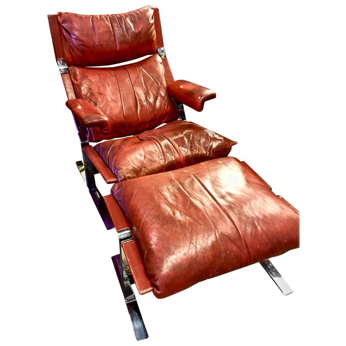 This an original Saporiti lounge chair and ottoman in its original rusty red supple Italian leather. The leather has acquired a lush patina; the chrome is original and in very good overall condition with no pitting or losses.