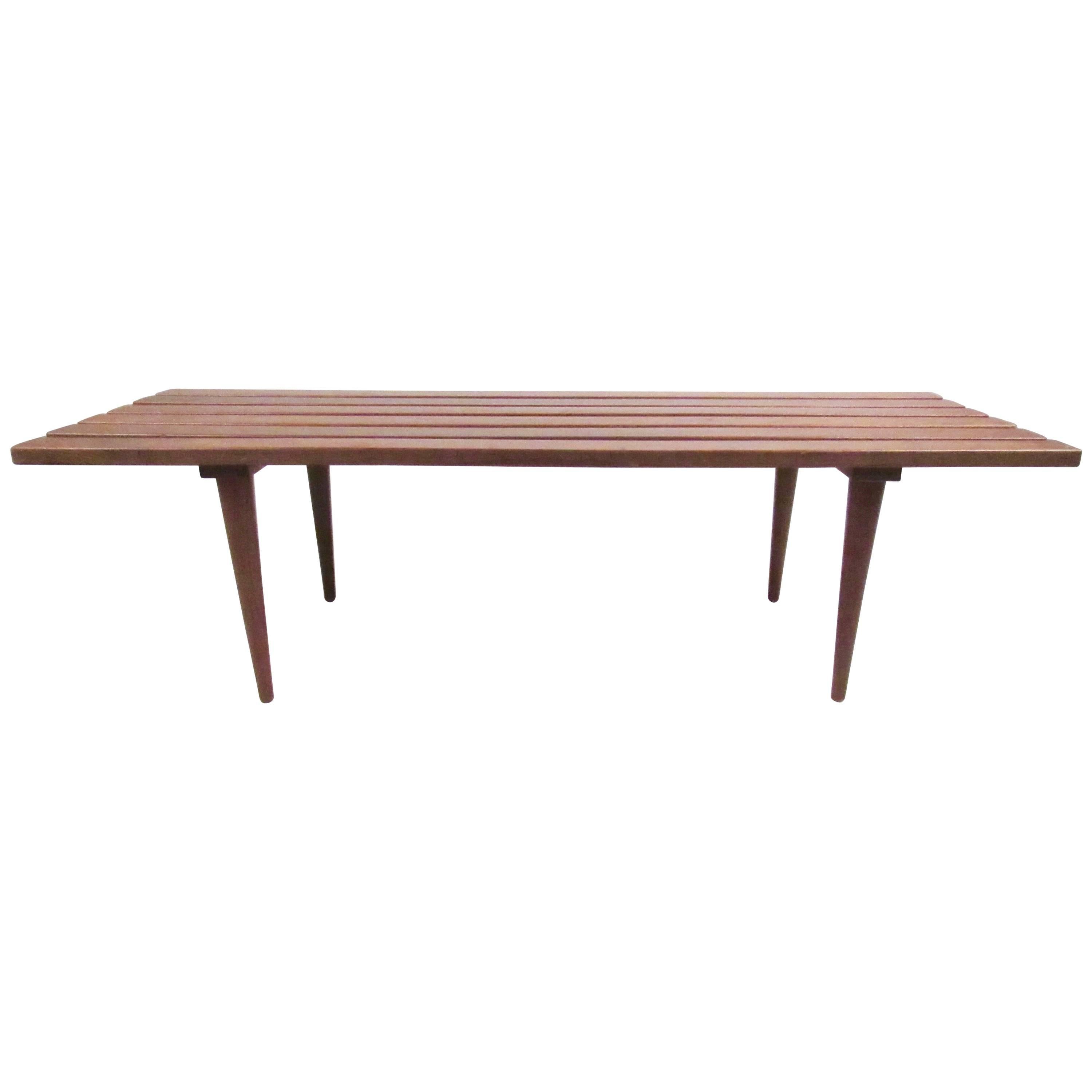 This vintage slat coffee table features Mid-Century construction with tapered legs, walnut finish, and sturdy construction. Perfect piece for use as a coffee table or as a bench. Please confirm item location (NY or NJ).