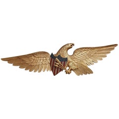 Aigle américain doré à ailes déployées empoignant un bouclier patriotique peint:: vers 1850