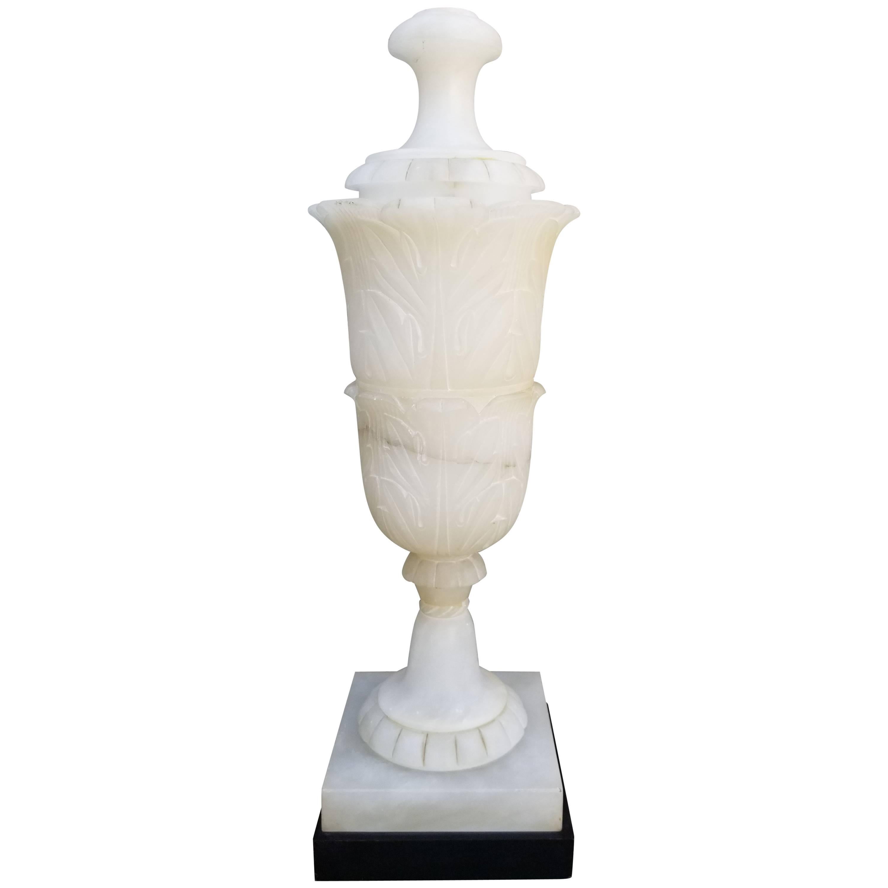 Monumental carved alabaster table lamp mounted to ebonized wood base. Alabaster urn measures 25