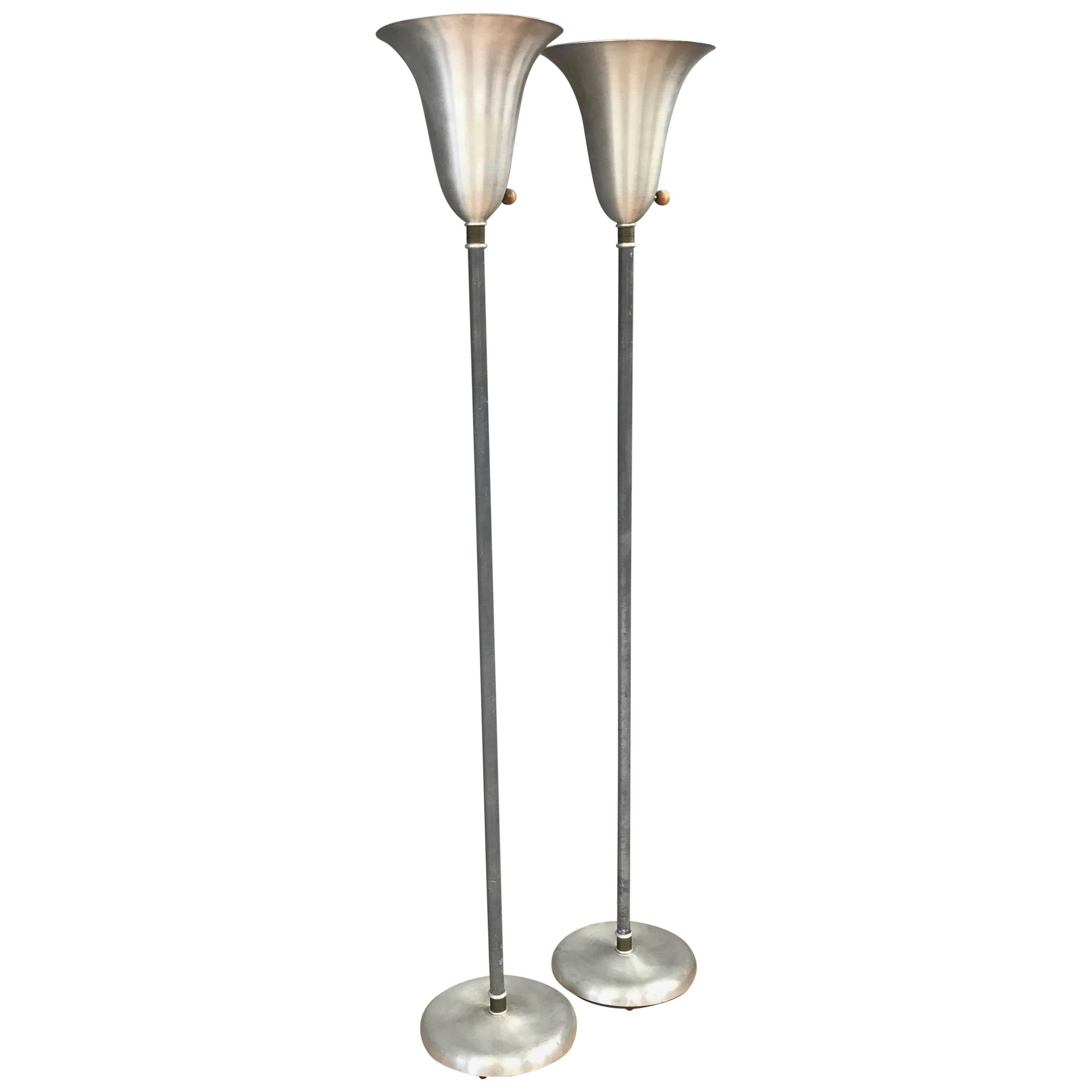 A pair of American Modern spun aluminium torchiere floor lamps with brass details by Russel Wright.

An unpretentious example of Wright’s singular ability to streamline and democratize Art Deco aesthetics and materials, a talent that proved hugely