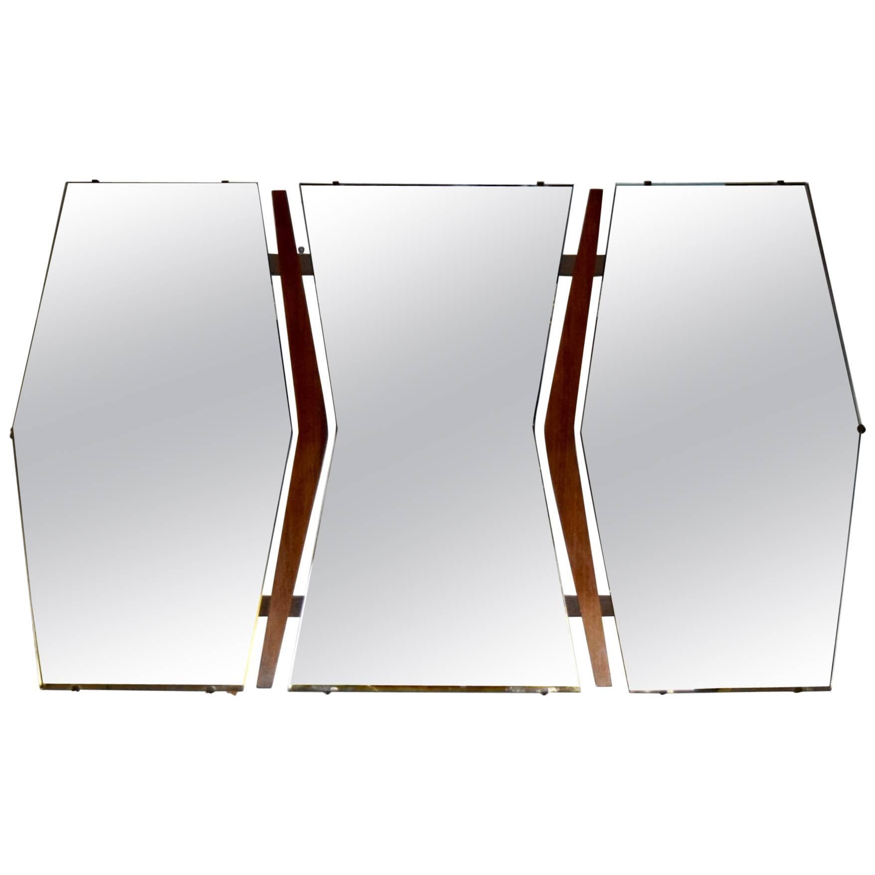 Wall mirror comprises three floating mirrors each cut on an angle with a contour wood frame. Both outside mirrors have an inverted shape to the centre the frame that follow the angles of each mirror's border.
