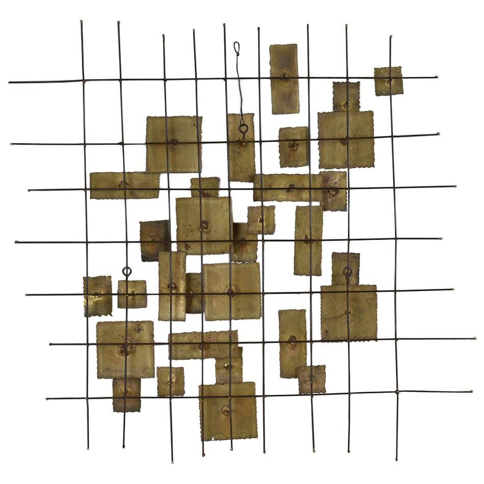 This 1960's Mid-Century Brutalist-style brass wall sculpture features varying sized geometric shapes on a woven brass base. This sculpture is intriguing, sturdy, and ready to be hung on any wall for years to come. 