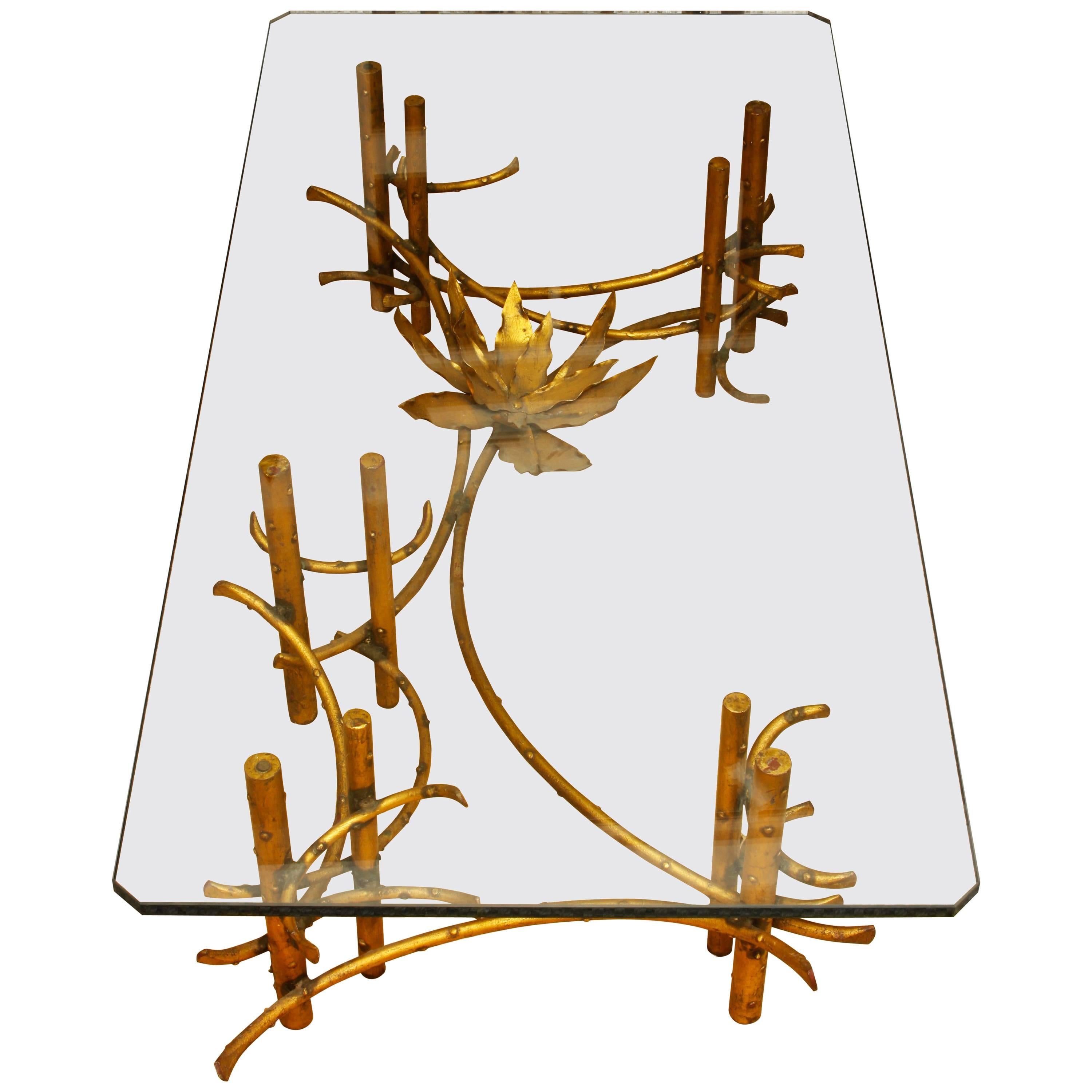A fantastic table attributed to the American sculptor Silas Seandel. The base is a wonderful asymmetrical design with a large leafy flower on one end, supporting a thick glass top. A work of art in itself, the table has both form and function.
