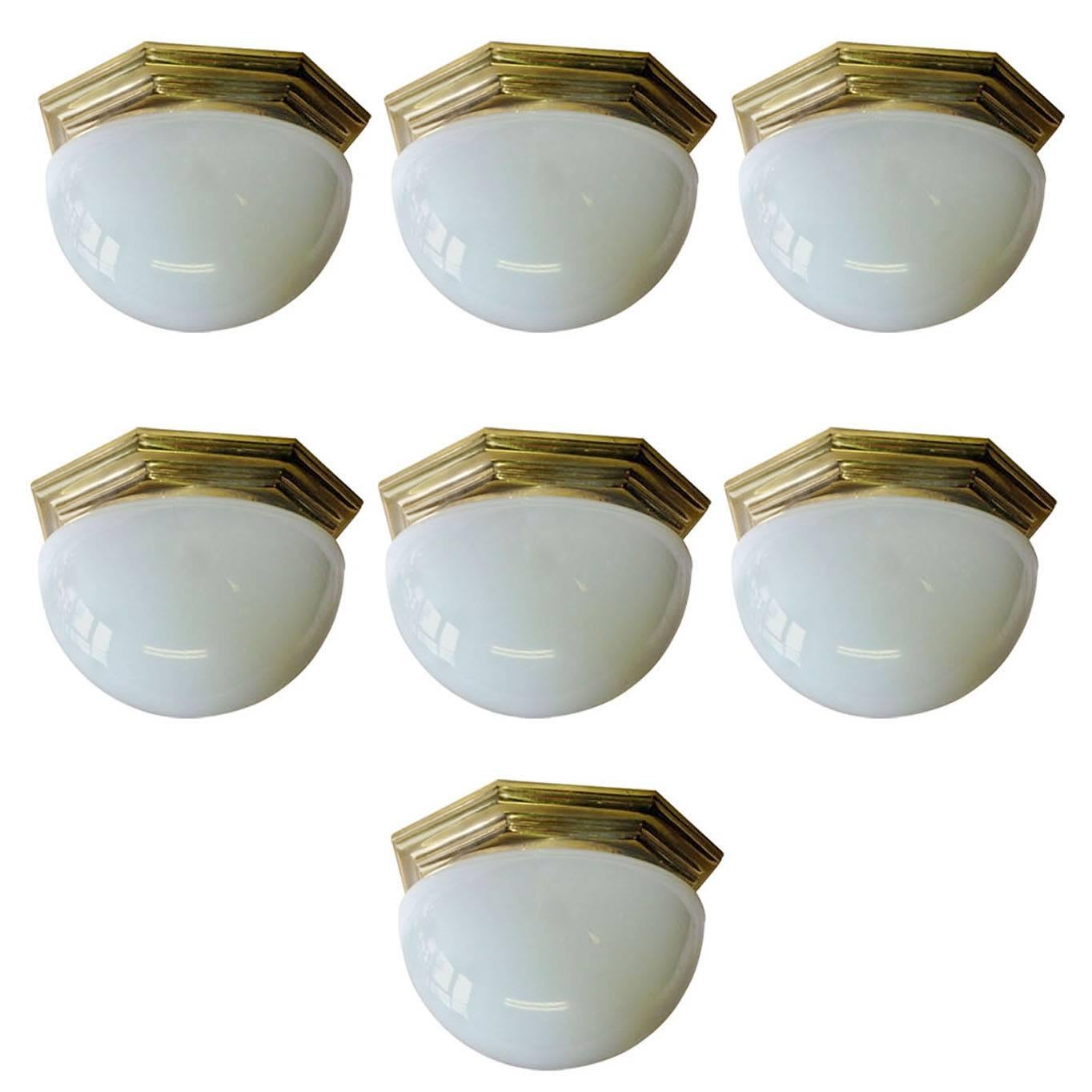 A set of seven French circa 1940's octagonal gilt bronze and milk glass flush mounted light fixtures with interior light. Sold individually.

Measurements:
Diameter: 12