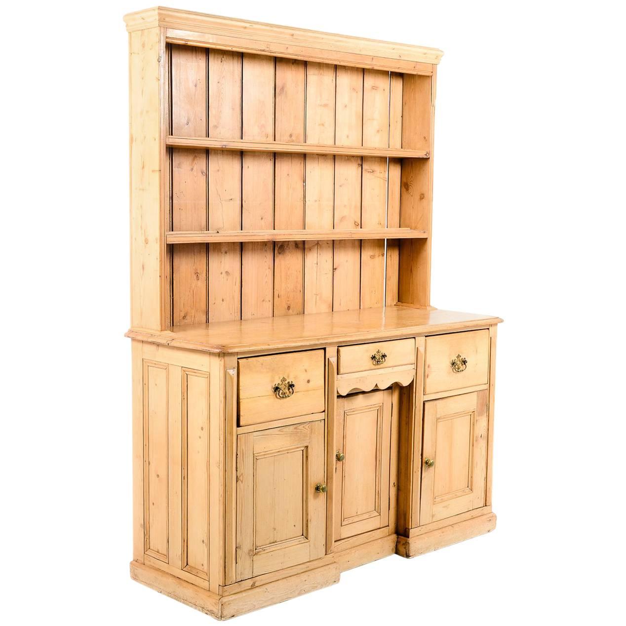 A charming antique 19th century solid pine country Welsh dresser, having three drawers over three cupboard doors, and open shelving above, circa 1850. Would be the focal point in a country kitchen or dining area.



