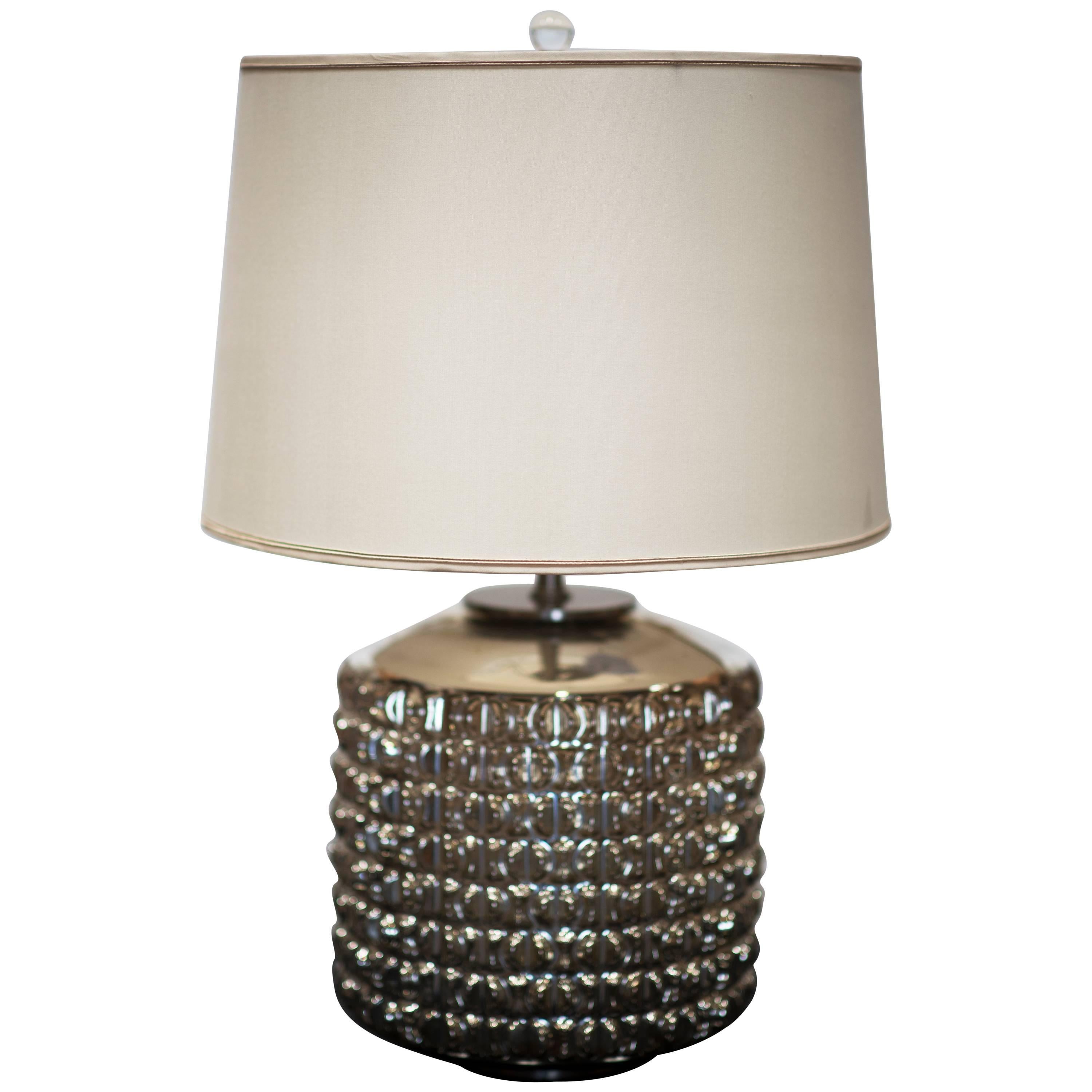 A stylish geometric form cylinder lamp in champagne mercury glass with a raised patterned finish circa 1960s. The intrinsic details of this lamp stands out even more when lighted. Instantly update your home with this gorgeous lighting design. The