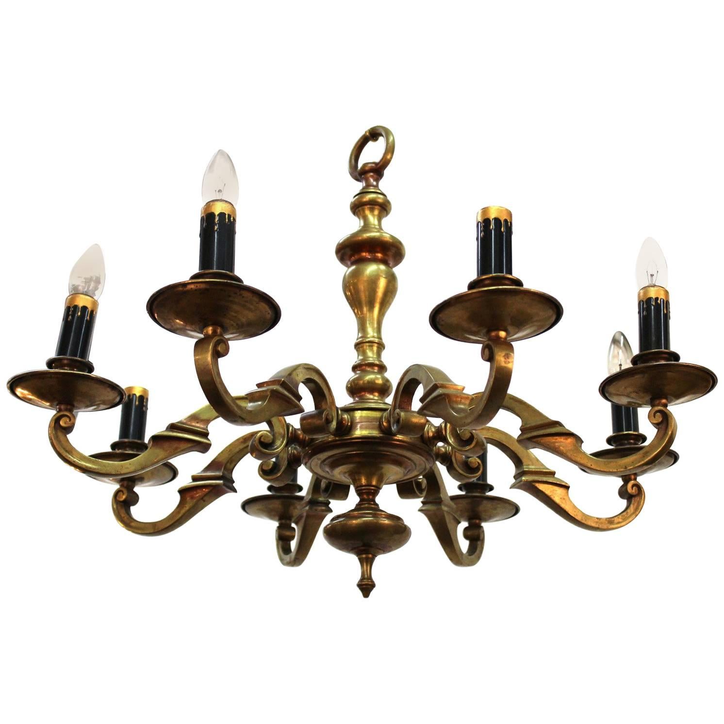 An early 1900s heavy eight-arm brass chandelier from the Arts & Crafts movement. Recently rewired to US standards. All original, takes medium base bulbs.