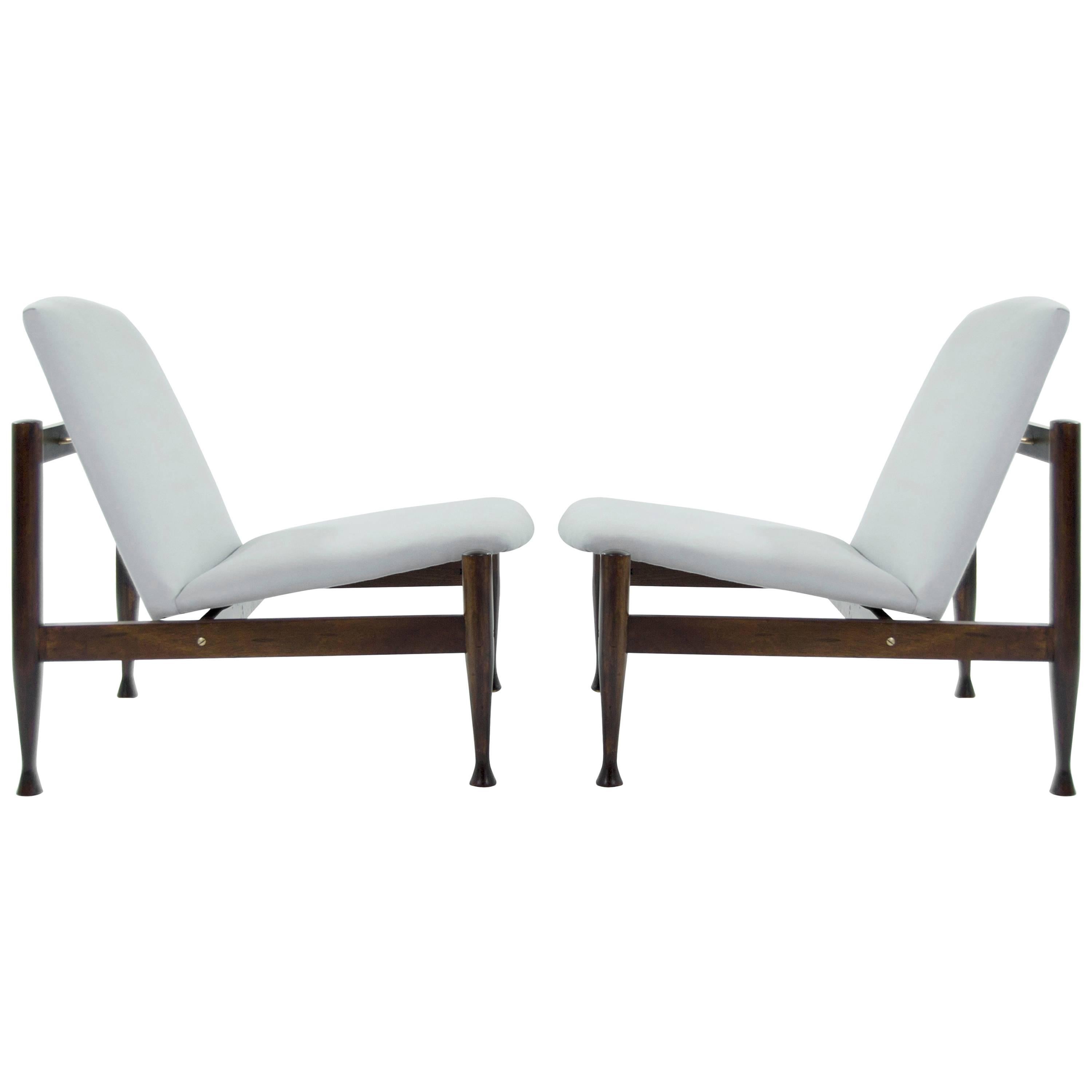 A fantastic pair of Danish Modern lounge chairs in the style of Finn Juhl (Japan Chairs). Newly upholstered in a light blue linen. Walnut frames fully restored, brass newly polished.