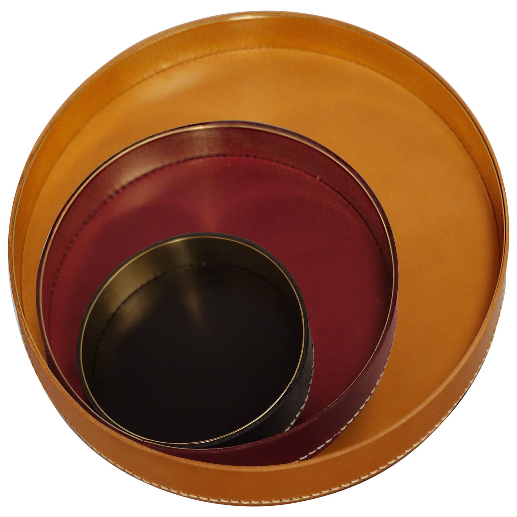Part of Les Few's Armance collection, this set of contemporary, round, leather and brass, modern, Minimalist, trays or centerpieces are made by artisans in Sweden. It is a set of three trays. The leather trays comes in cognac, burgundy and black.