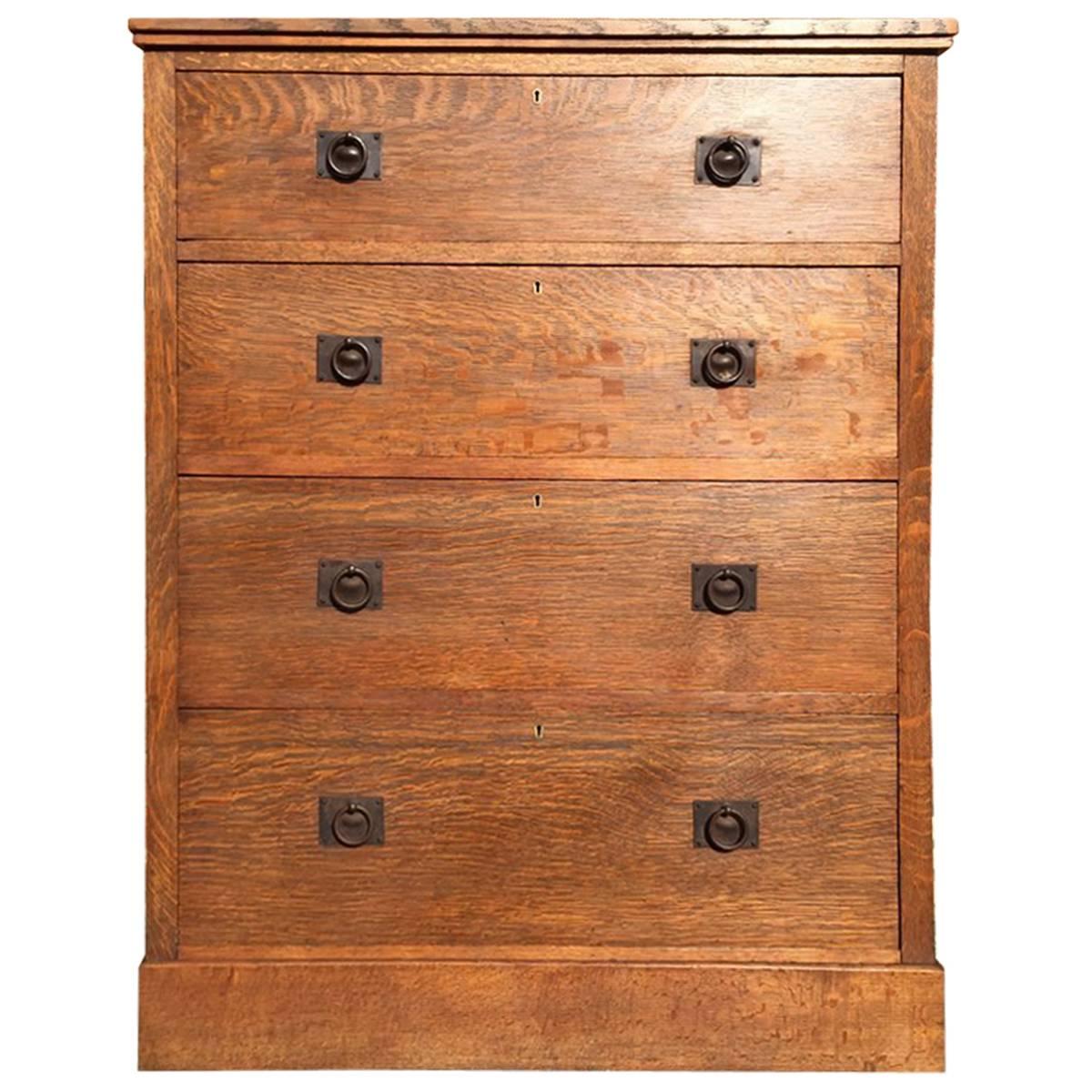 Heals attri, A Tall Arts & Crafts Oak Chest of Drawers with Steel Handles