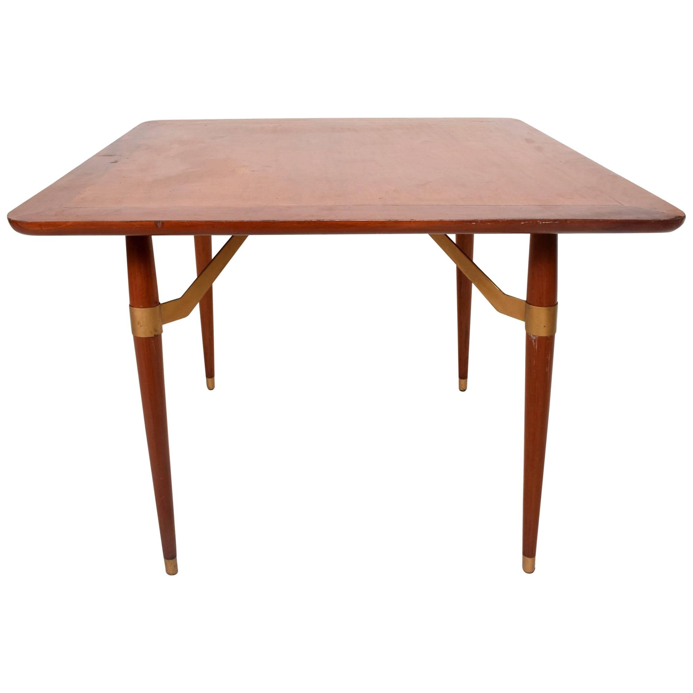 For your consideration a Mexican modernist game or dining table in mahogany wood.

Legs have a tapered finish with stretchers painted in gold or brass.

Constructed with dove tail joints. 

Measures: 28 5/8