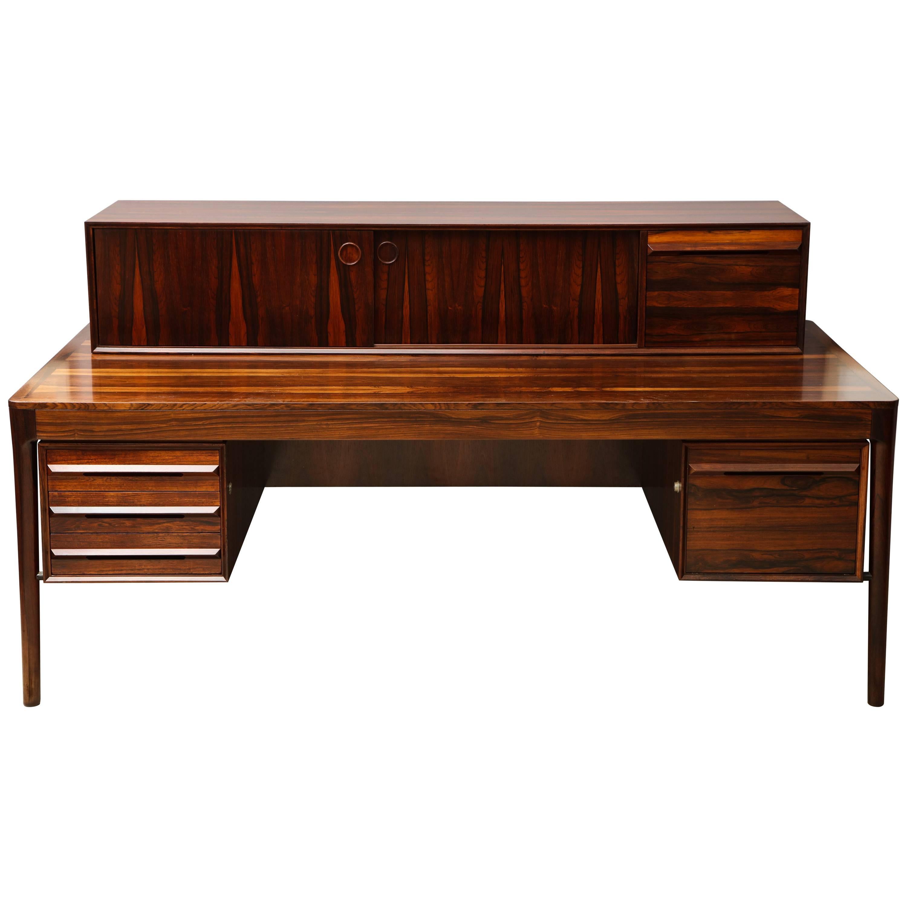 An exceptional and large rosewood desk made by Haug Snekkeri in Norway in the 1960s. The high contrast of the natural rosewood is dramatic and displays a beautiful pattern throughout. The lower left hand side with three drawers and lower right with