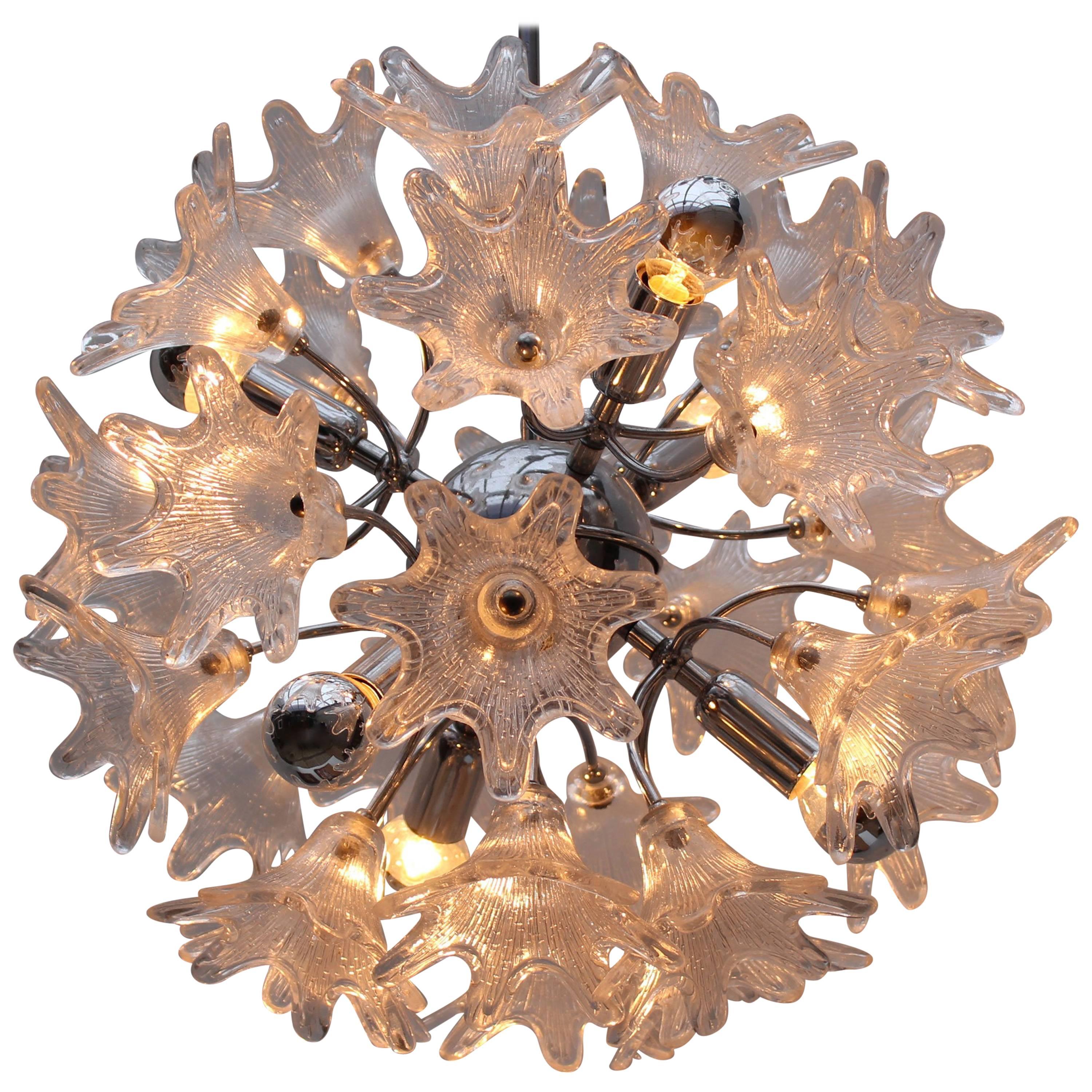Wonderful midcentury Italian sputnik chandelier designed by Paolo Venini for VeArt in 1960. The chandelier has a stylish chrome frame and 30 Murano glass flowers. When lit the light hits the flowers and creates a beautiful sight.
This chandelier