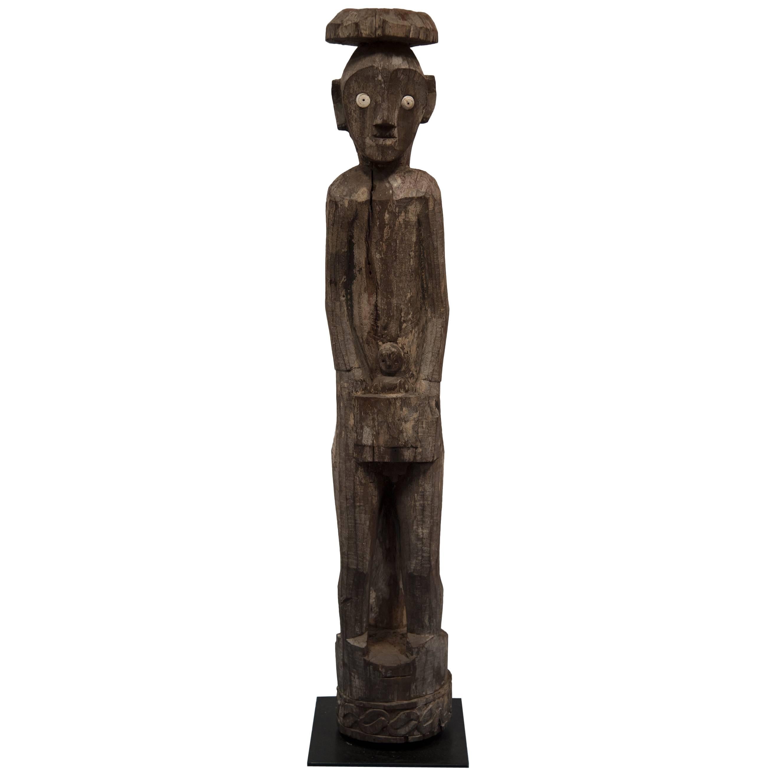 Eine geschnitzte Holzfigur von Maile mit Kind. Eine aus Hampadong Kalimantan geschnitzte, stehende Skulptur des Volkes der Iban Dayak [Ot Danum Dayak] aus den inneren Regenwäldern von BORNEO. Eine außergewöhnlich seltene Hartholz und Muschel