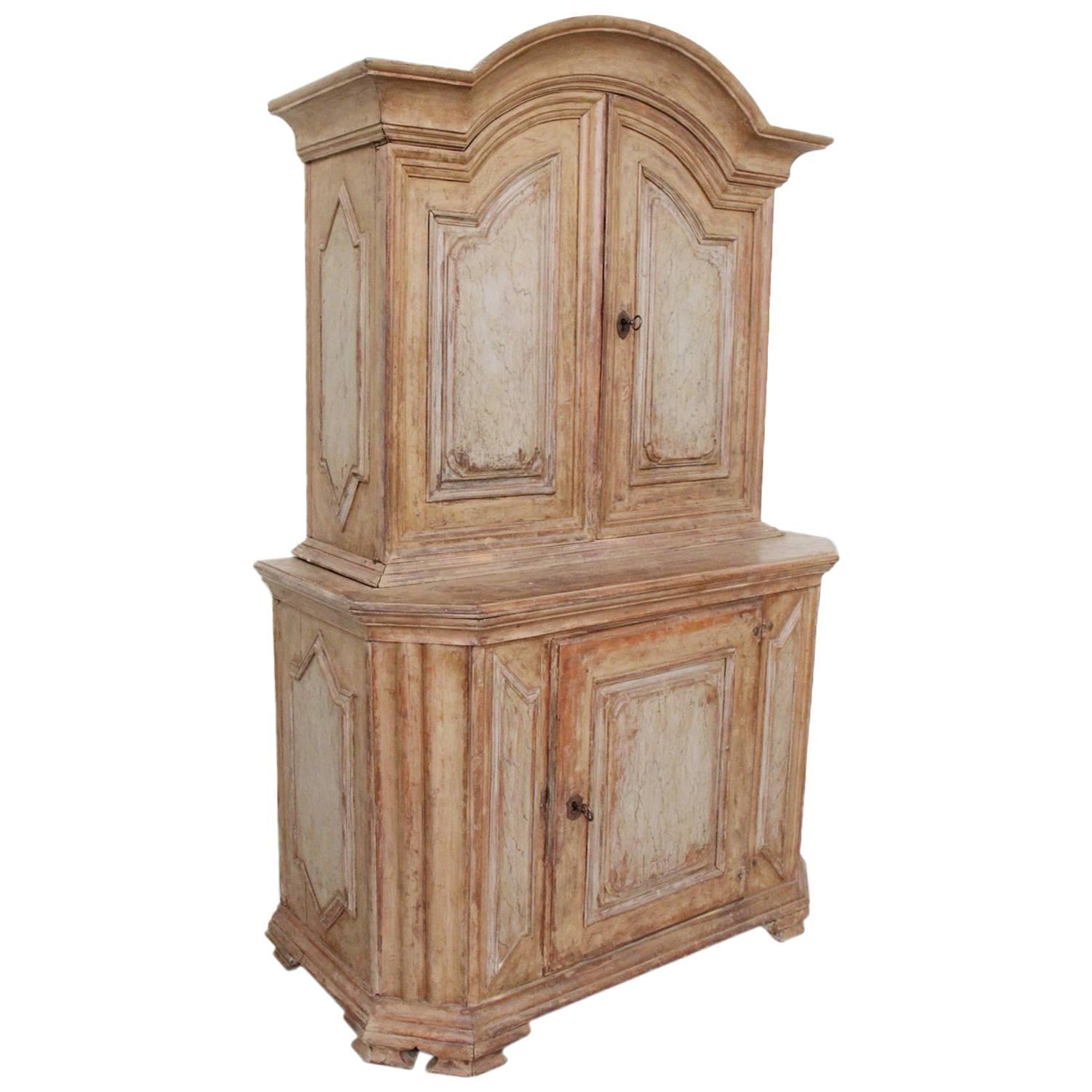 A rare 18th century Swedish Baroque period, circa 1720, two-part cabinet in original, untouched paint with arched cornice and richly carved, raised panel doors. Original working locks and keys. There is a note in one of the drawers dated 1717,