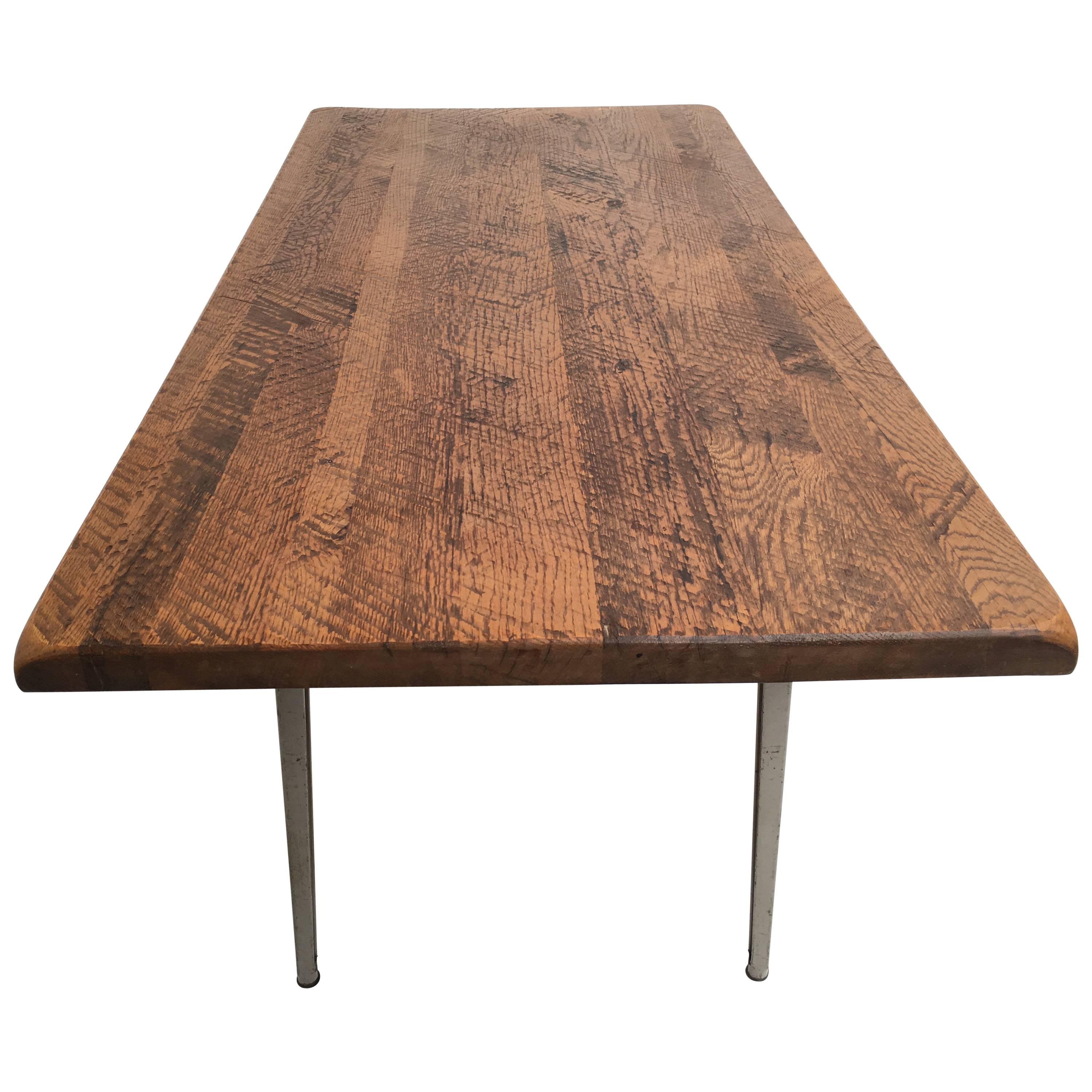 Un plateau en chêne massif rustique vintage récupéré a été monté sur un cadre de table 