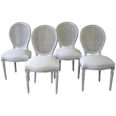 Set of Four Louis XVI Carved and Painted French Cane Back Dining Chairs