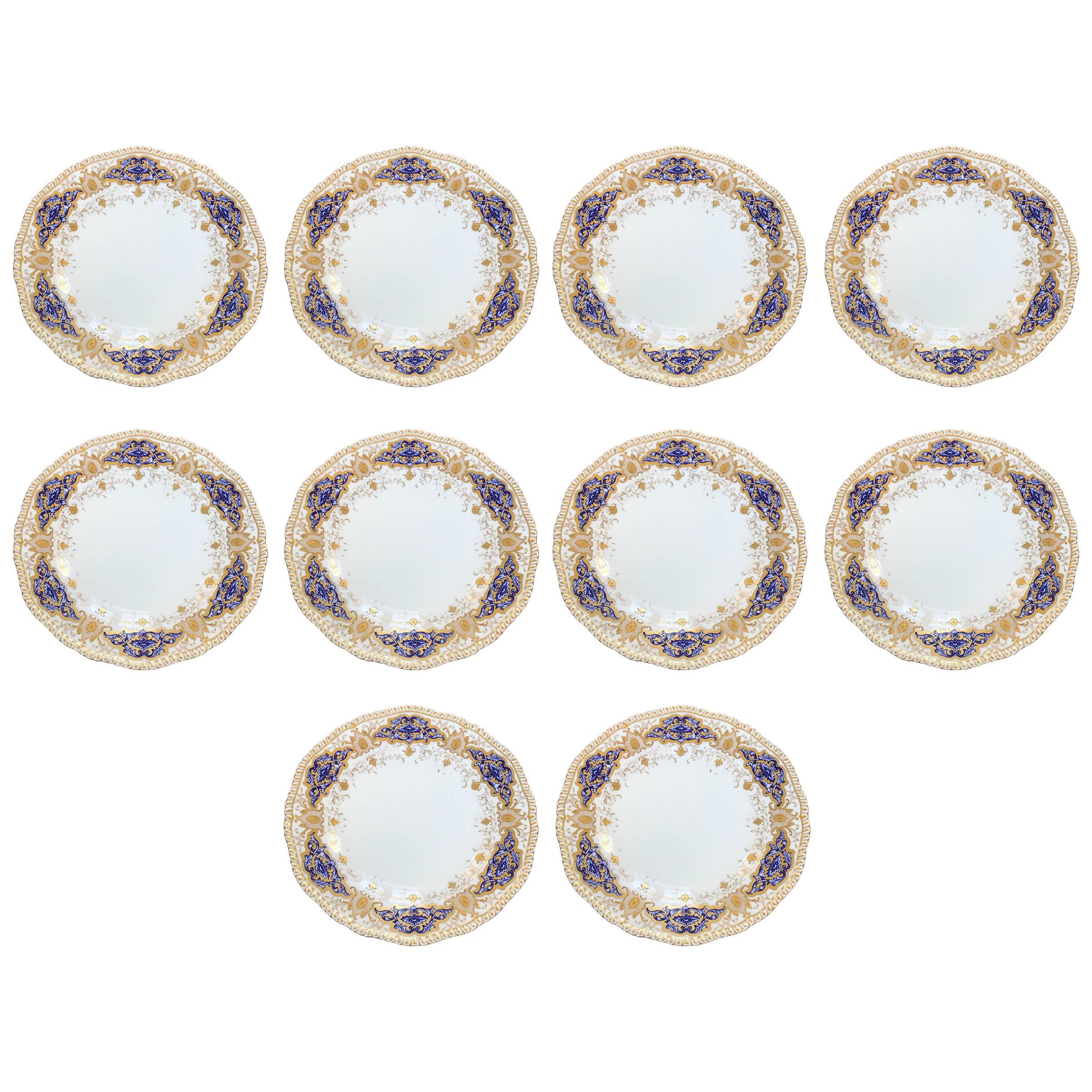 This gorgeous set of 10 coalport dinner plates were made in England, circa 1890-1900 for Spaulding & Co. Chicago as the retailer. 
They are beautifully decorated in a foliate design in flat and raised gold framing cobalt blue cartouches.
The