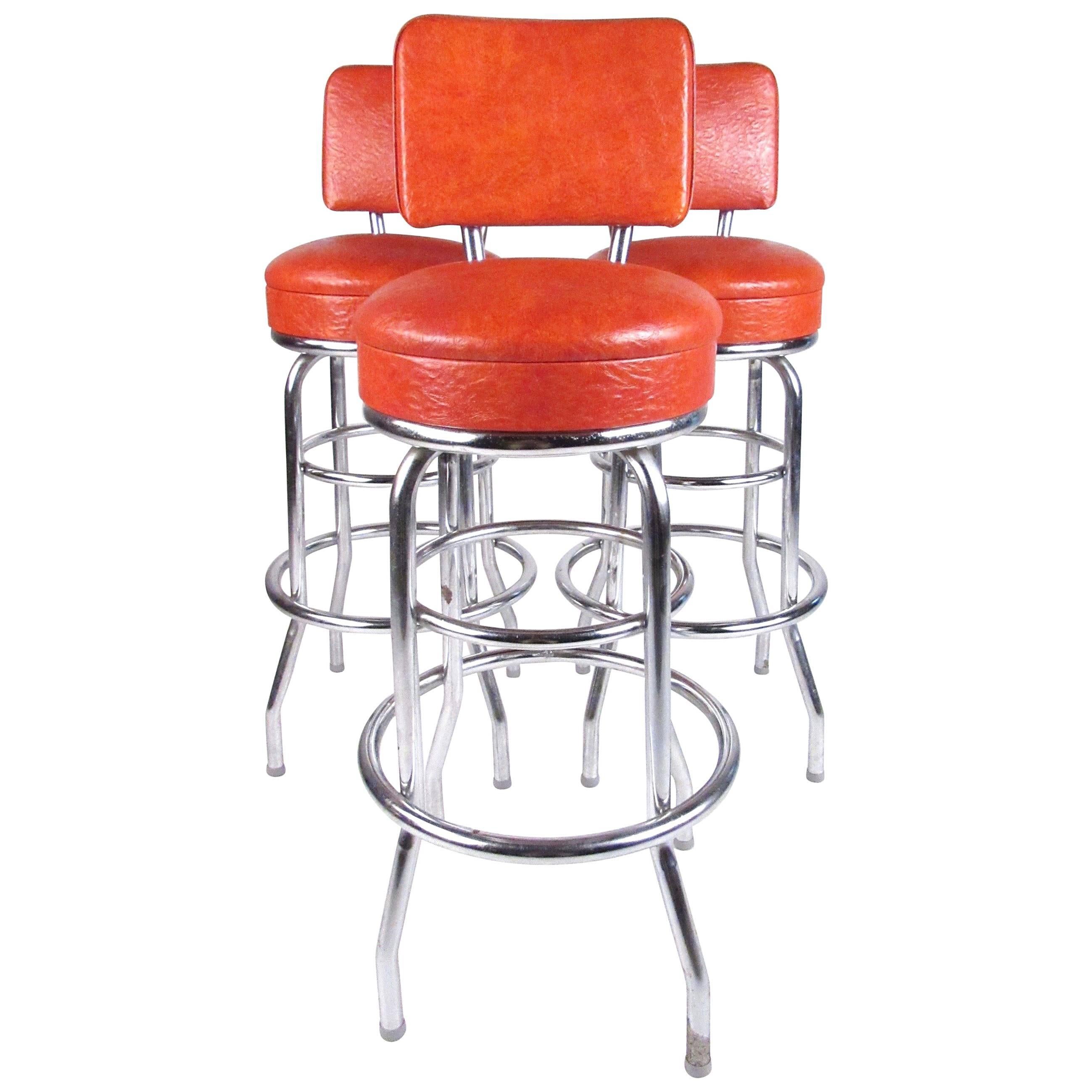 This stylish retro set of vintage modern bar stools feature vinyl swivel seats, sturdy metal frames, and circular metal footrest. Perfect set of bar height stools for home or business bar seating. 
Please confirm item location (NY or NJ).