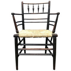 William Morris:: A Classic Arts & Crafts Ebonised Armchair from the Sussex Range.