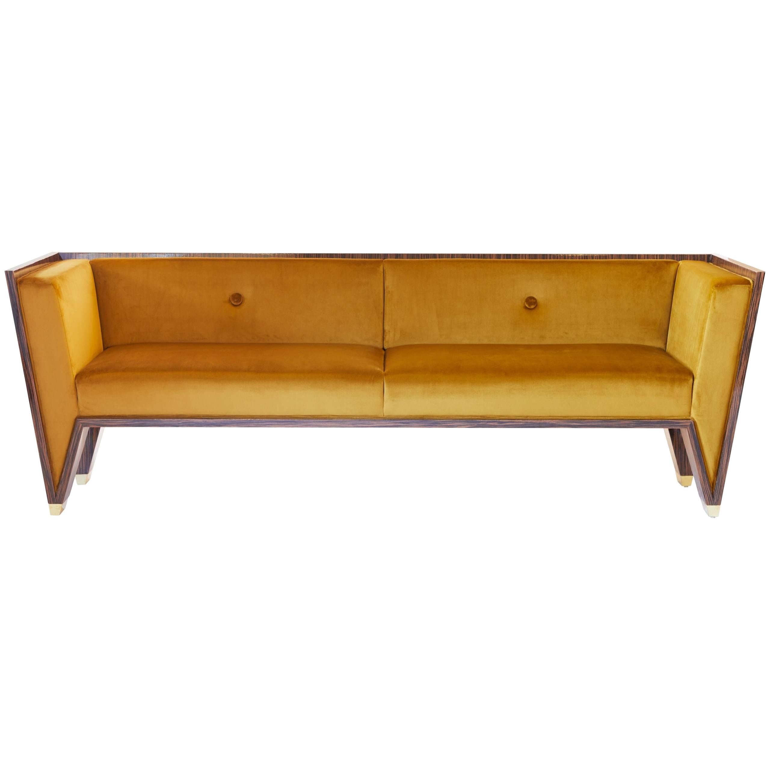 The Wedge Sofa is a timeless handmade contemporary Art Deco sofa. This striking sofa is well-proportioned and bold. The velvet is like butter and Macassar Ebony has a high gloss lacquer finish. The feet are made out of solid brass and have a mirror