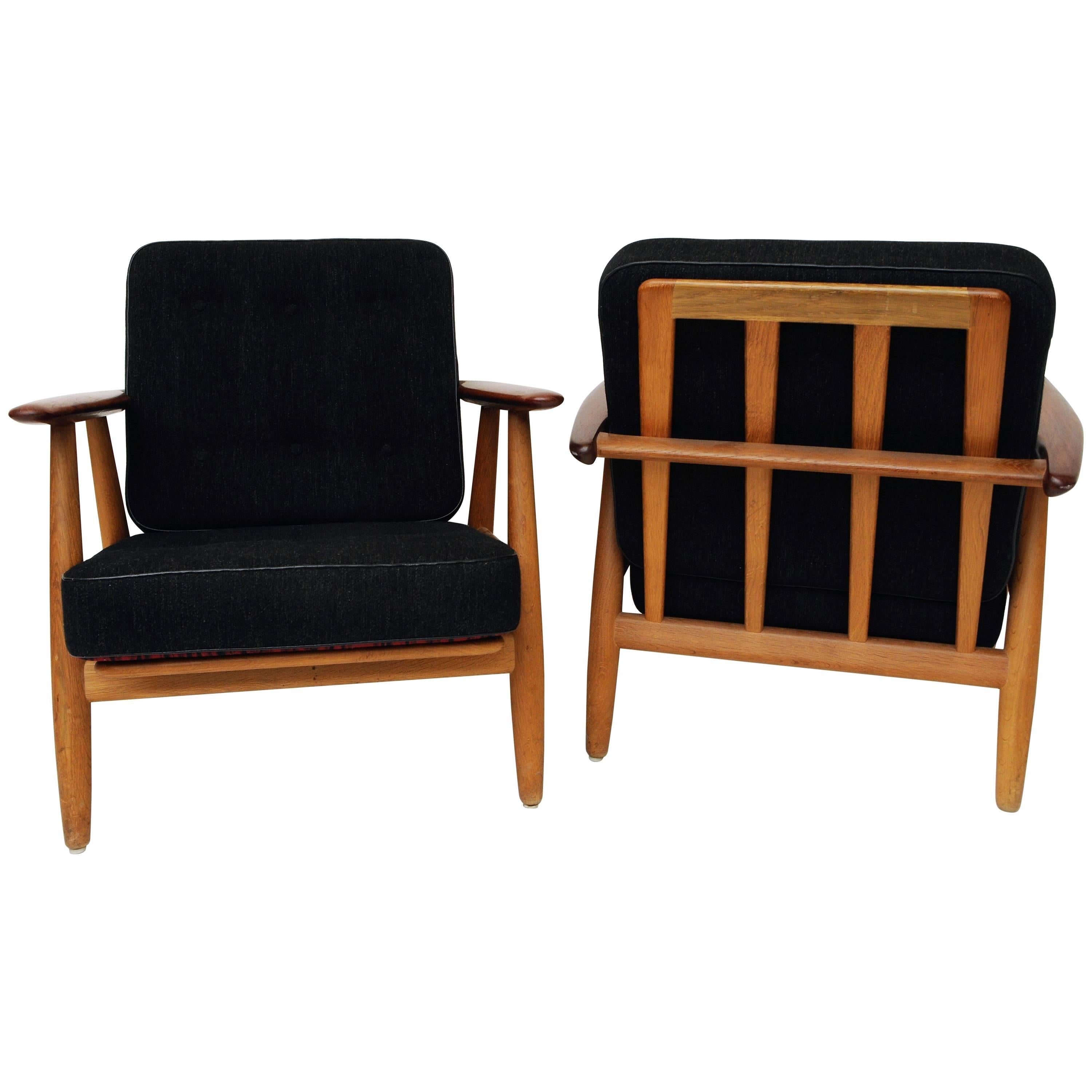 Beautiful pair of the cigar chair model GE240 by Hans J. Wegner for GETAMA Denmark. Produced 1955.  teak and oak arms and leg. The set has reversible patterned black and a red back -and seat cushions so you are able to switch the colors of the seats