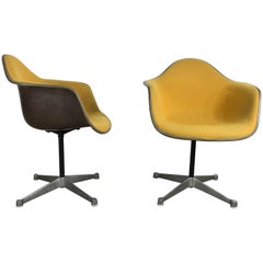 Pair of Charles and Ray Eames Swivel Padded Arm Shell Chairs, Two-Tone