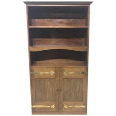 Liberty & Co. A Slim Arts & Crafts Walnut Bookcase with Stylised Copper Hinges