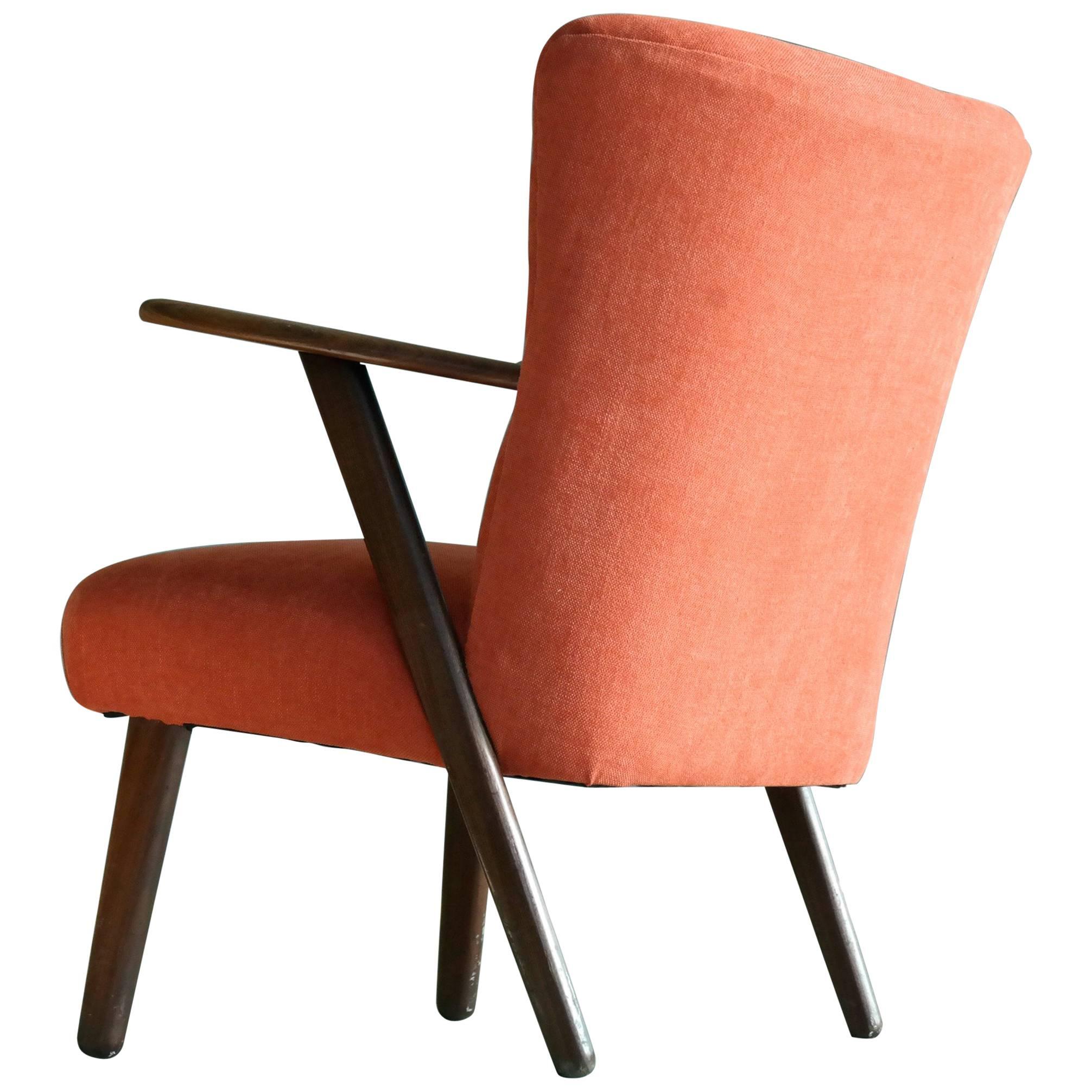 A very cool Danish lounge or cocktail chair from the 1950s in the style of Kurt Olsen. Beautiful wood grain and well crafted sturdy construction yet comfortable and light weight. Newly upholstered in a fresh orange color, great accent chair for the