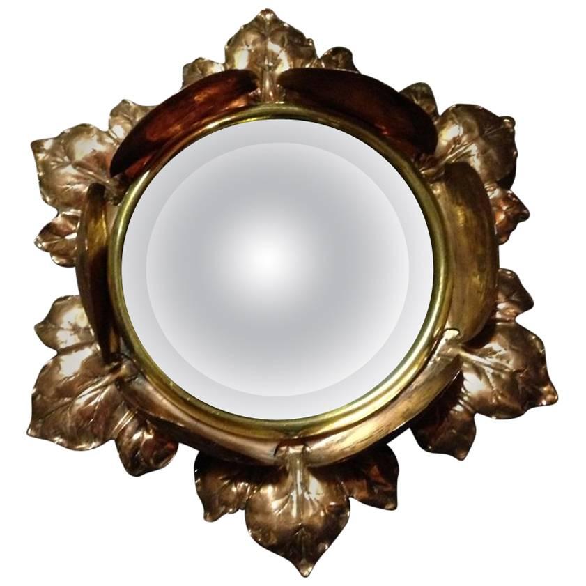 Un miroir circulaire biseauté en cuivre Arts & Crafts en forme de bouton de fleur
