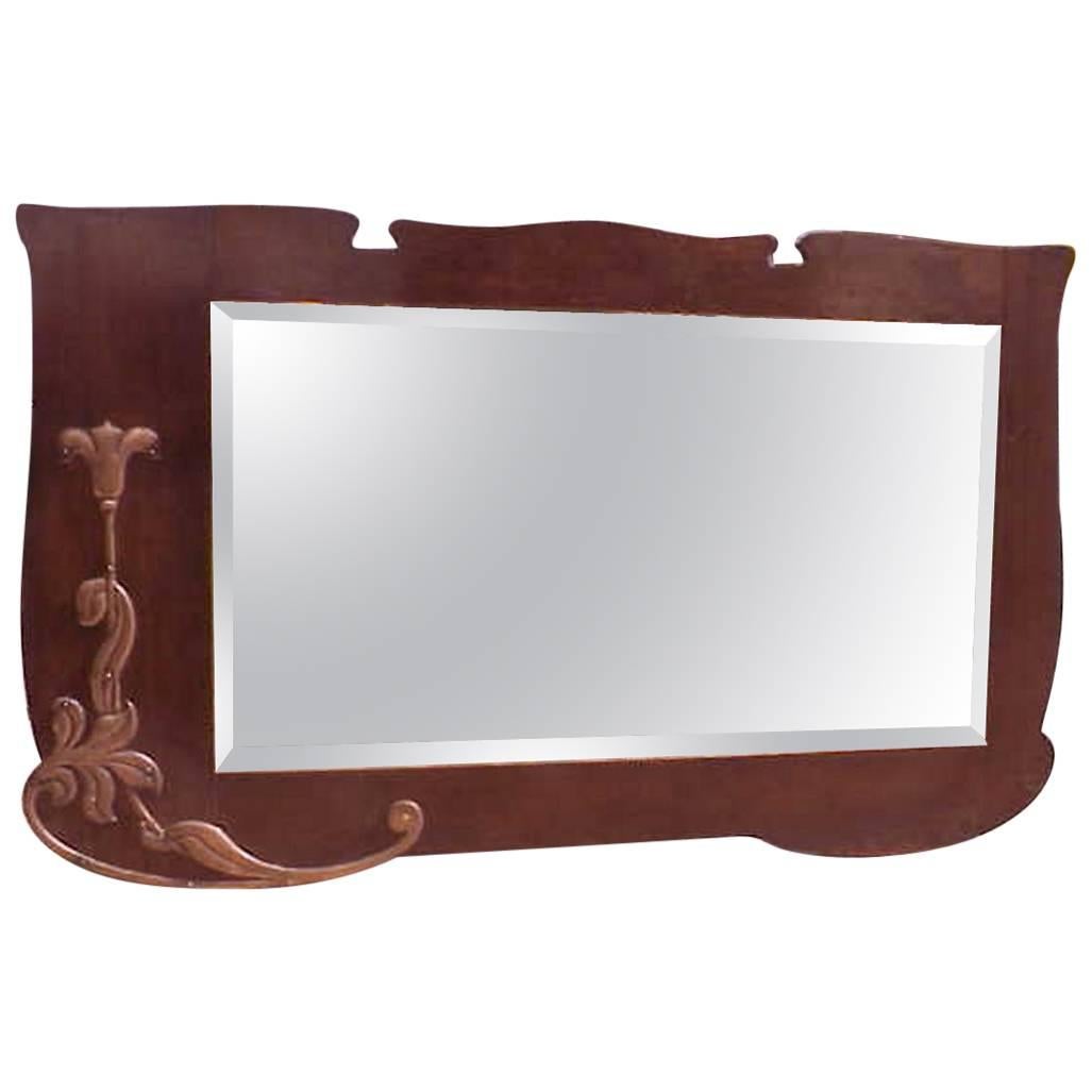 An Arts & Crafts Shaped Oak Bevelled Mirror with Stylised Floral Copper Details