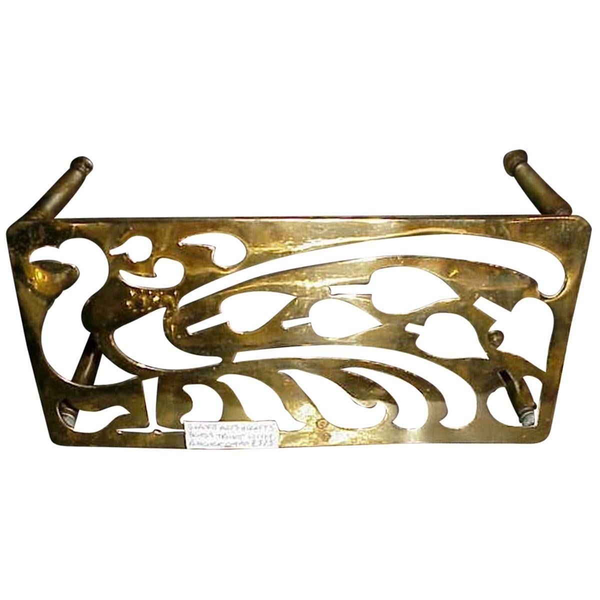 An Aesthetic Movement Brass Trivet with Peacock Fret Work, on Turned Legs