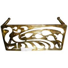 An Aesthetic Movement Brass Trivet with Peacock Fret Work, on Turned Legs