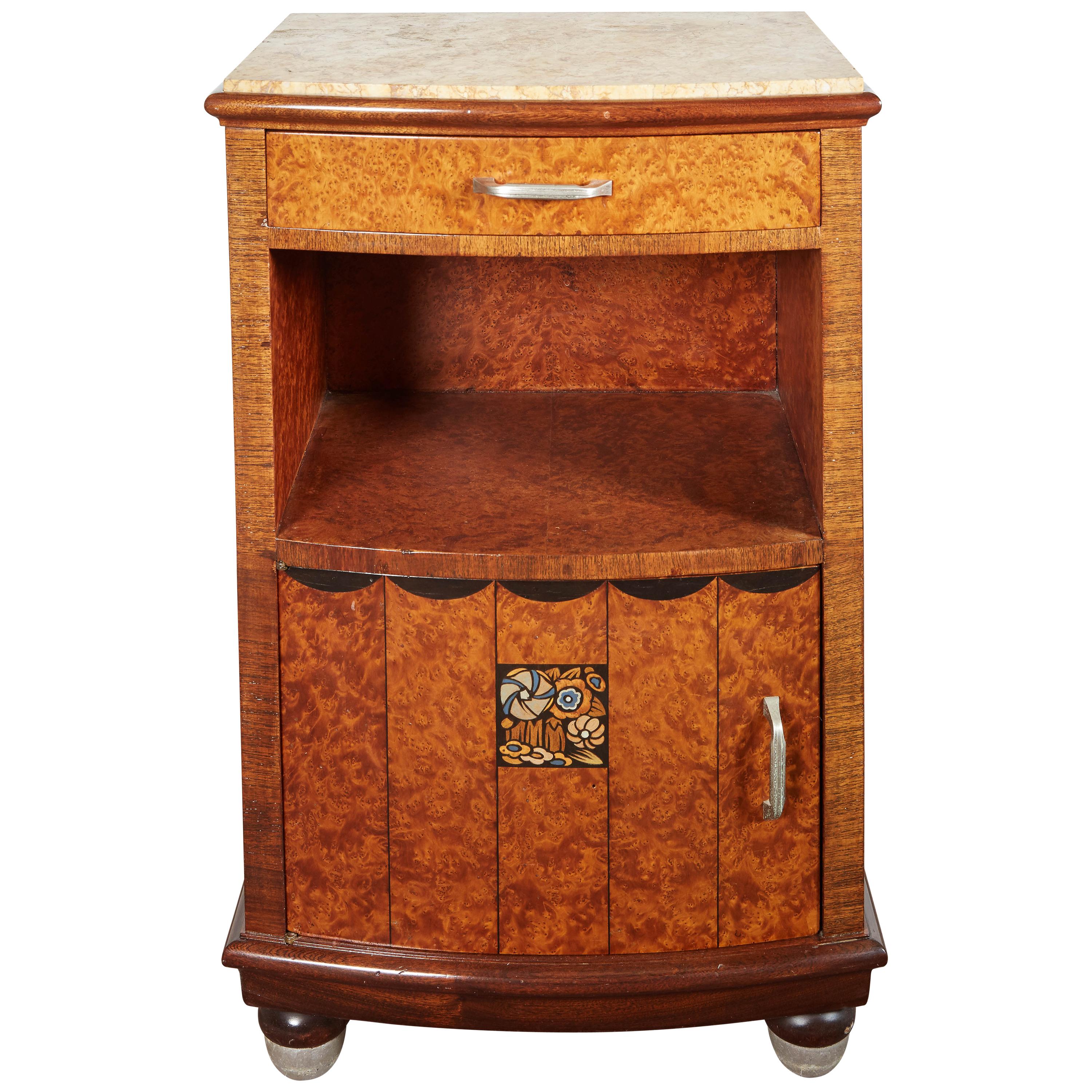 A pair of fully figured thuya wood, marquetry inlaid end tables having original veined marble tops in light yellow, burnt umber and ochre.
The spacious top drawer sits atop an open space above a single door with fitted marble interior, while raised