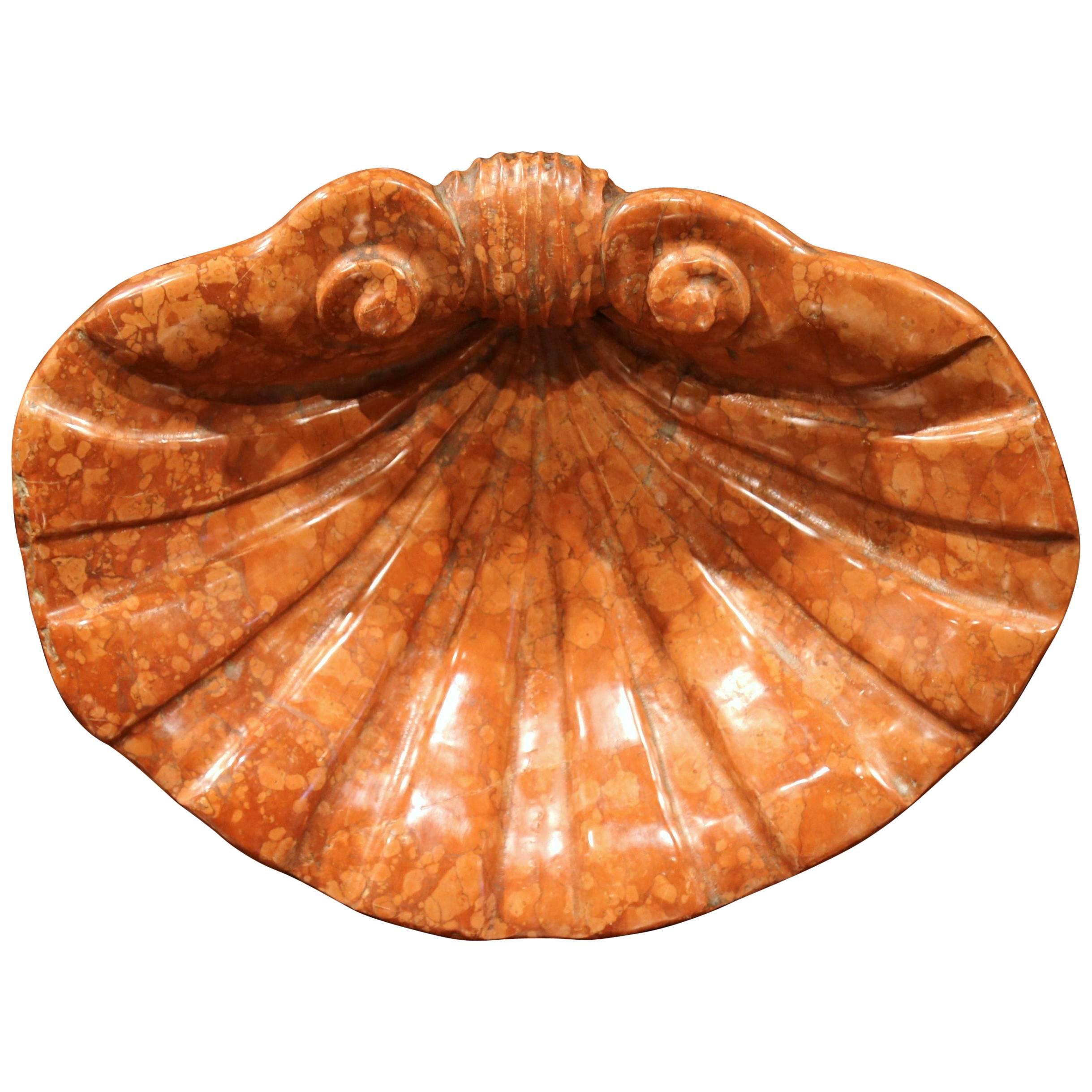 This beautiful and large carved marble stoup was crafted in France, circa 1750. Found in a small church, the antique red stone basin is carved in the shape of a large seashell with an elegant demilune shape. The Classic, decorative marble piece is