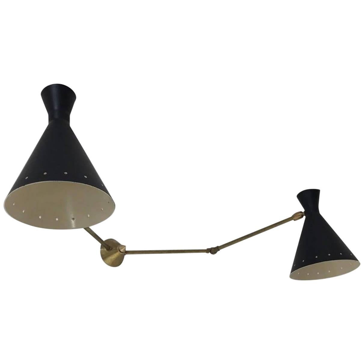 Two Italian double wall sconces in the style of Stilnovo. Each features two articulated brass arms (articulate 360) and cone shades (5.12 diameter x 7 tall). One has a black exterior with white interior. One has a white exterior and interior.