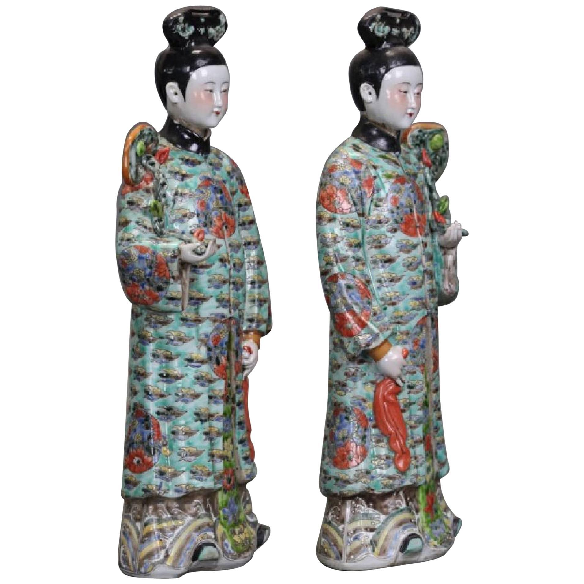 A lovely pair of Chinese export porcelain figures of court ladies with nodding heads, late Qing Dynasty, circa 1900, China.
The elegant ladies dressed in gorgeous traditional robes in the Manchu court style. The robes of greenish blue with a dense