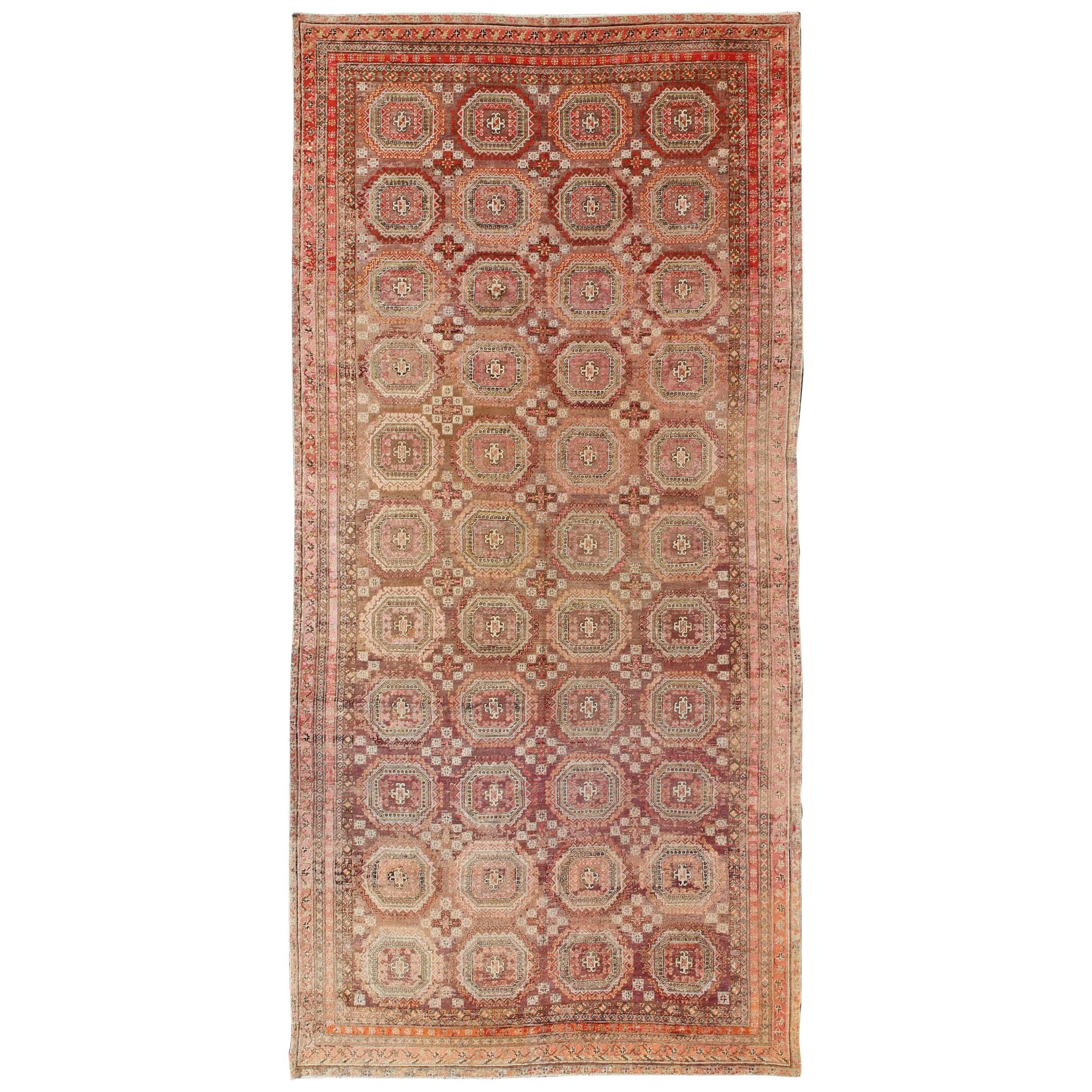 Antique Large Khotan Rug with Repeating Medallion Design in Maroon / Red For Sale