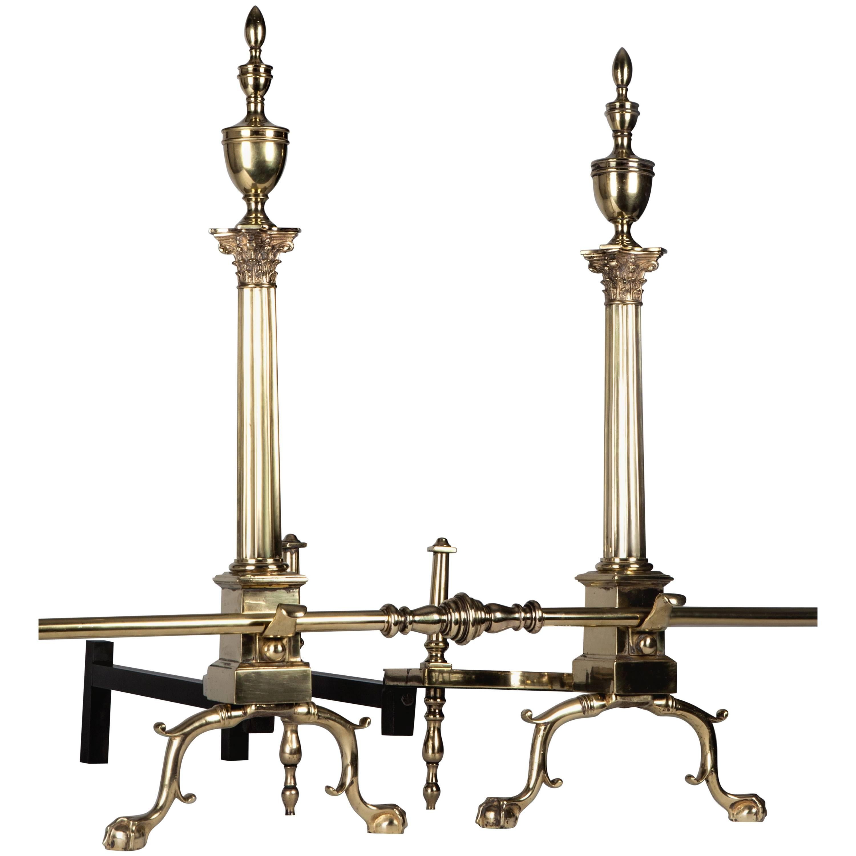 AFP0591
A pair of antique cast brass paw-footed andirons set with fluted Corinthian column bodies surmounted by turned urn form finials. Complete with a brass fender bar custom made in the Remains workshop. Circa 1920s.

Dimensions:
Overall: 30-1/2