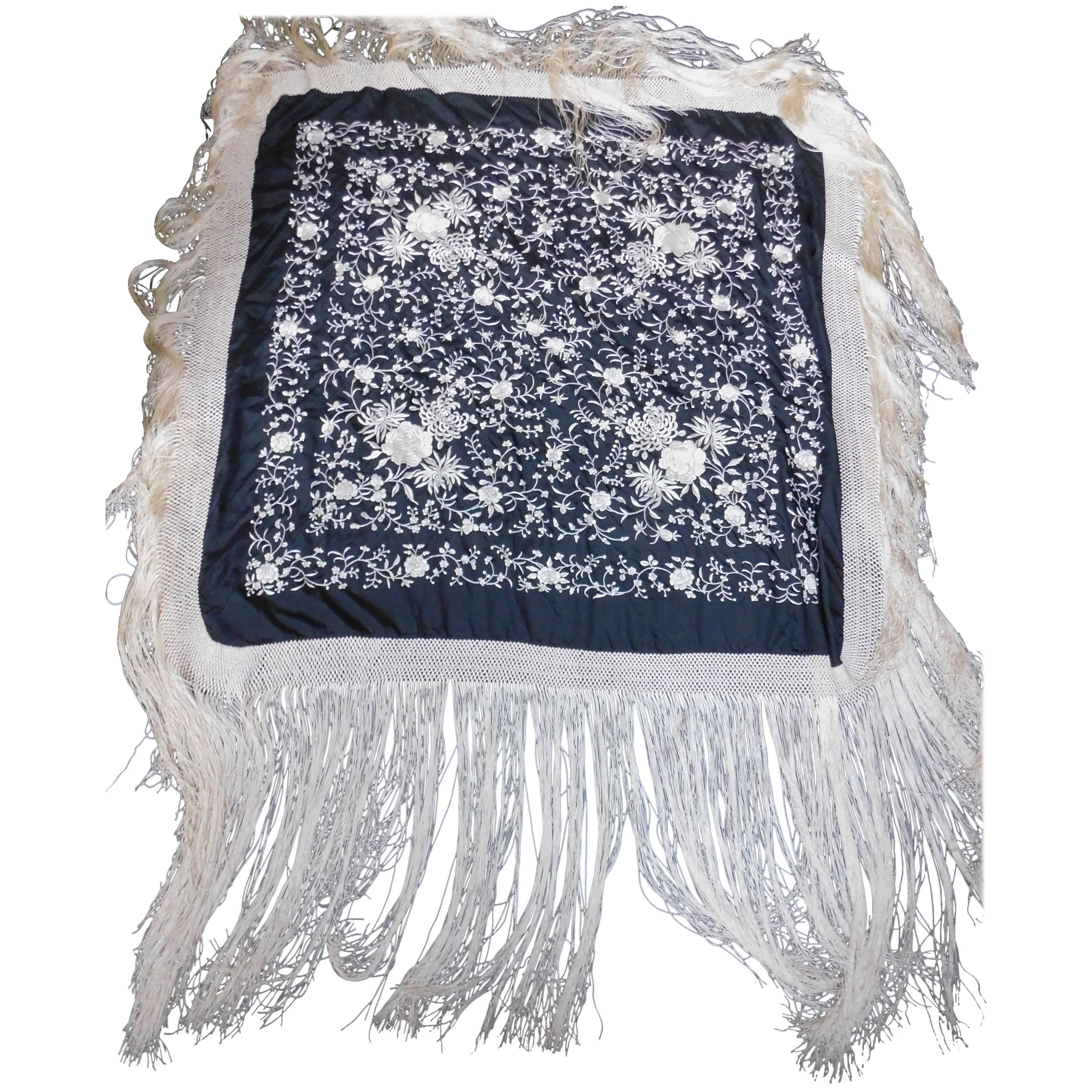 Stunningly elegant black and white Cantonese embroidered silk piano shawl. Black silk heavily hand embroidered with white silk thread and completely finished all around with long macrame tied white very long silk fringe. In excellent