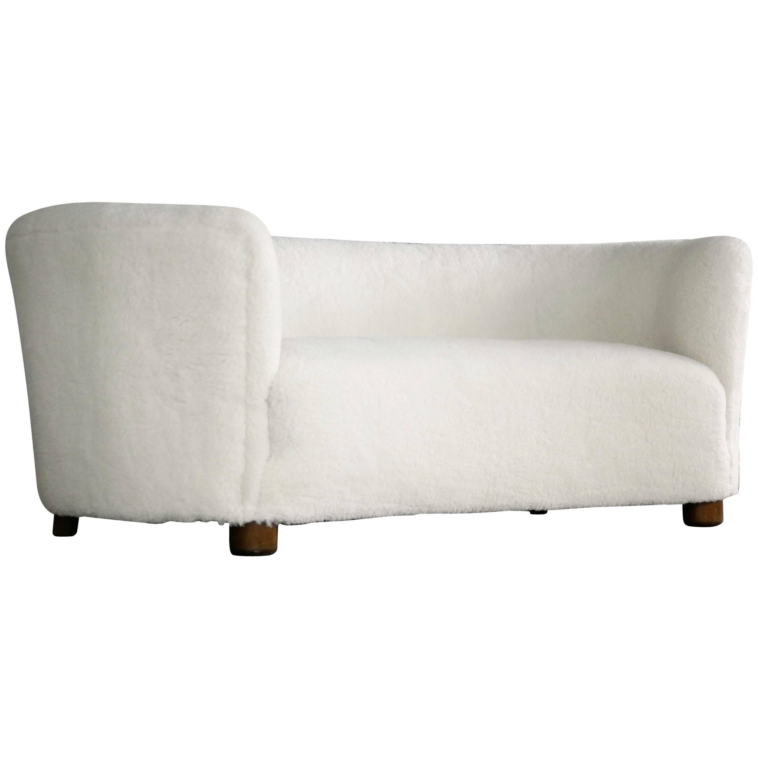 Viggo Boesen attributed banana shaped or curved sofa reupholstered in new lambs wool made by Slagelse Møbelværk in the 1940s. This sofa will make strong statement in any room. Beautiful round lines and with Boesen's iconic round feet. Fully