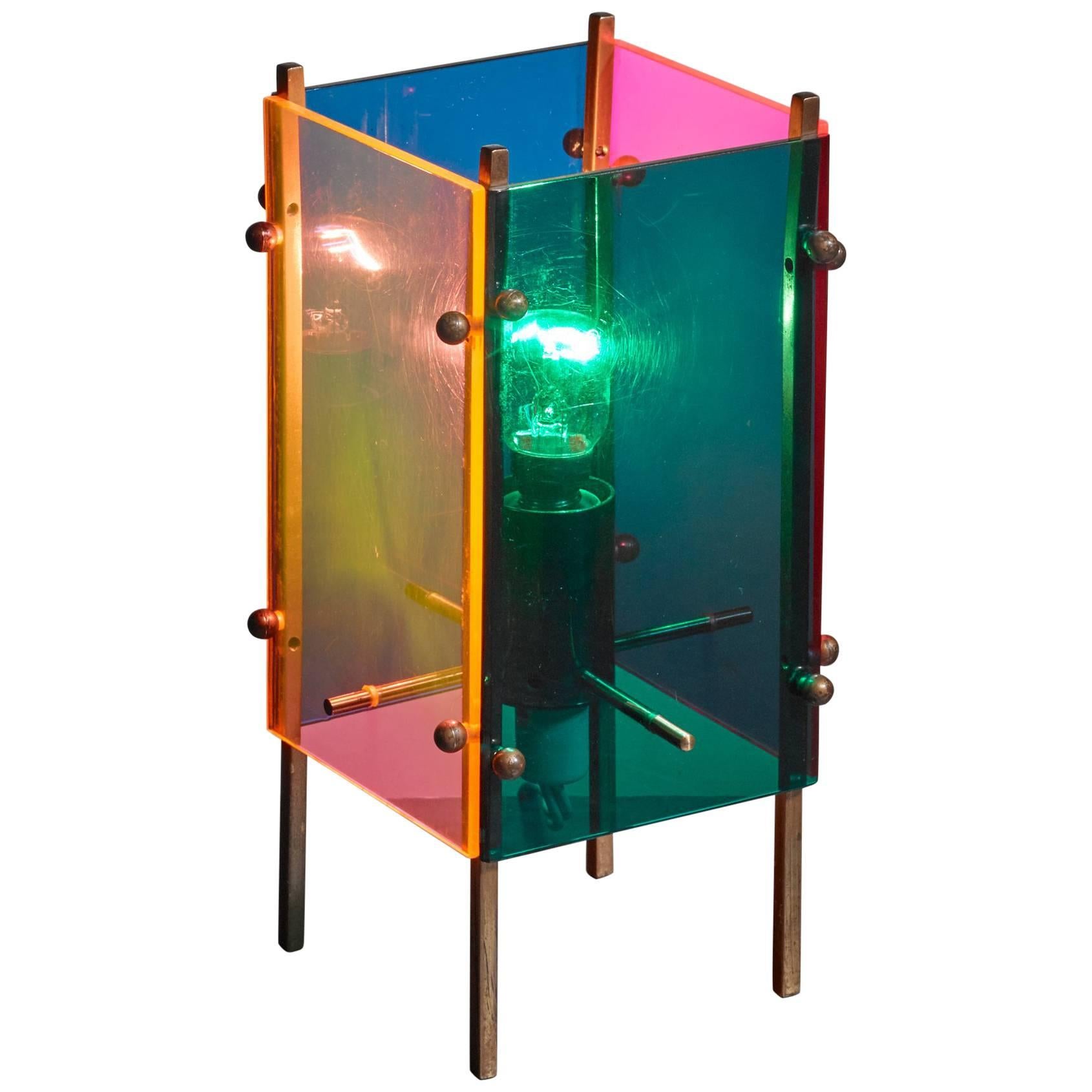 A table lamp attributed to Angelo Lelli for Arredoluce, made of blue, green, orange and yellow plexiglass panels on a brass frame.